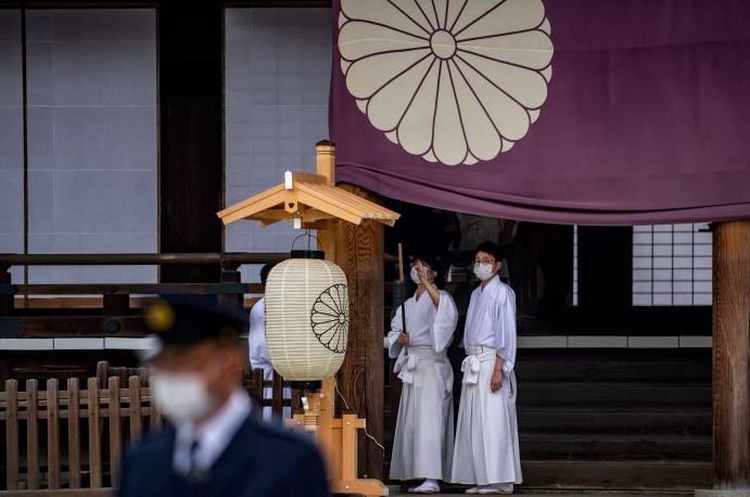 Staf kuil Yasukuni di Tokyo memakai masker saat akan menyiapkan ritual musim semi tahunan pada 21 April.