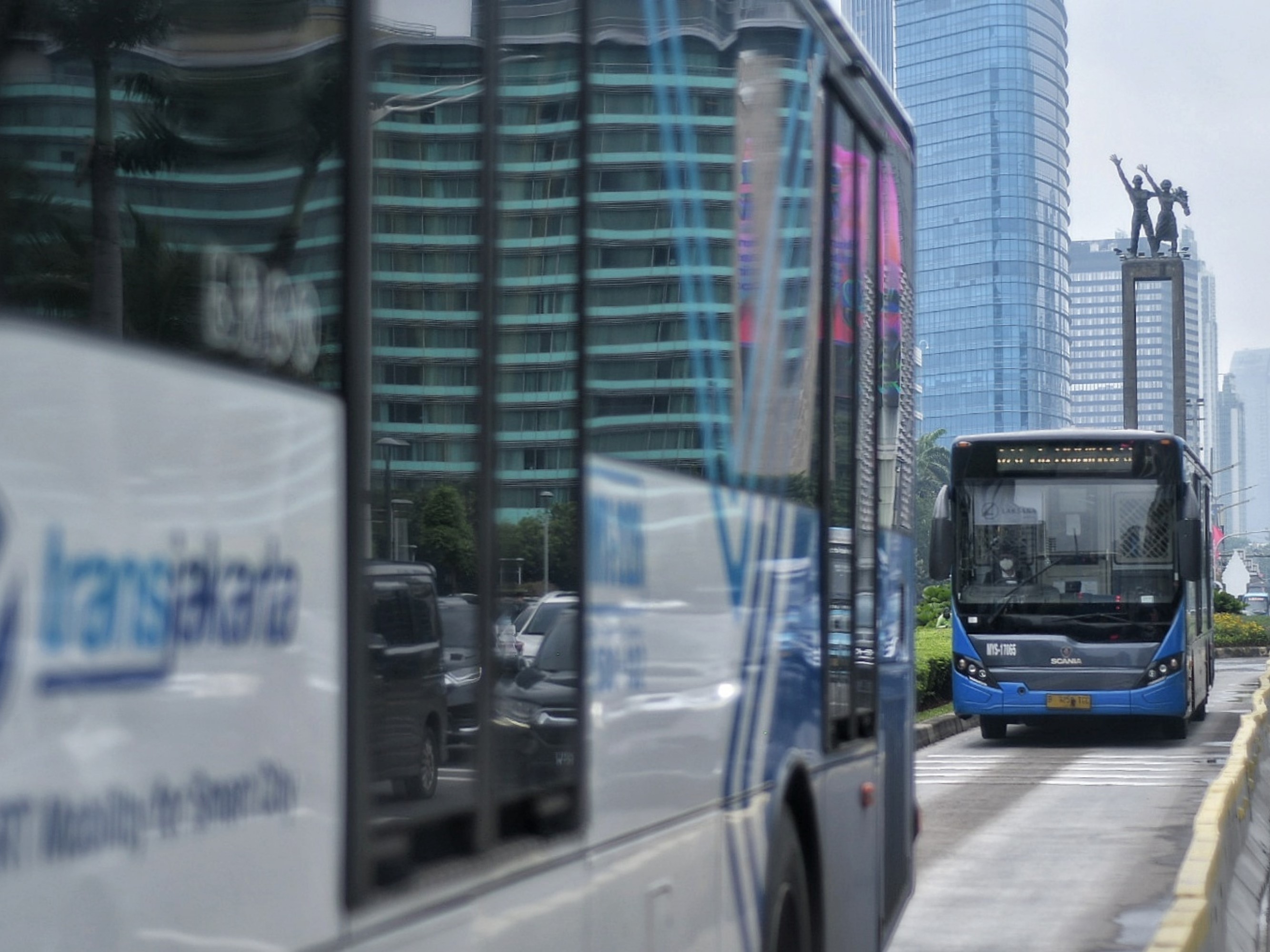  Armada bus TransJakarta melintasi kawasan Bundaran Hotel Indonesia, Jakarta, Selasa (7/12/2021).