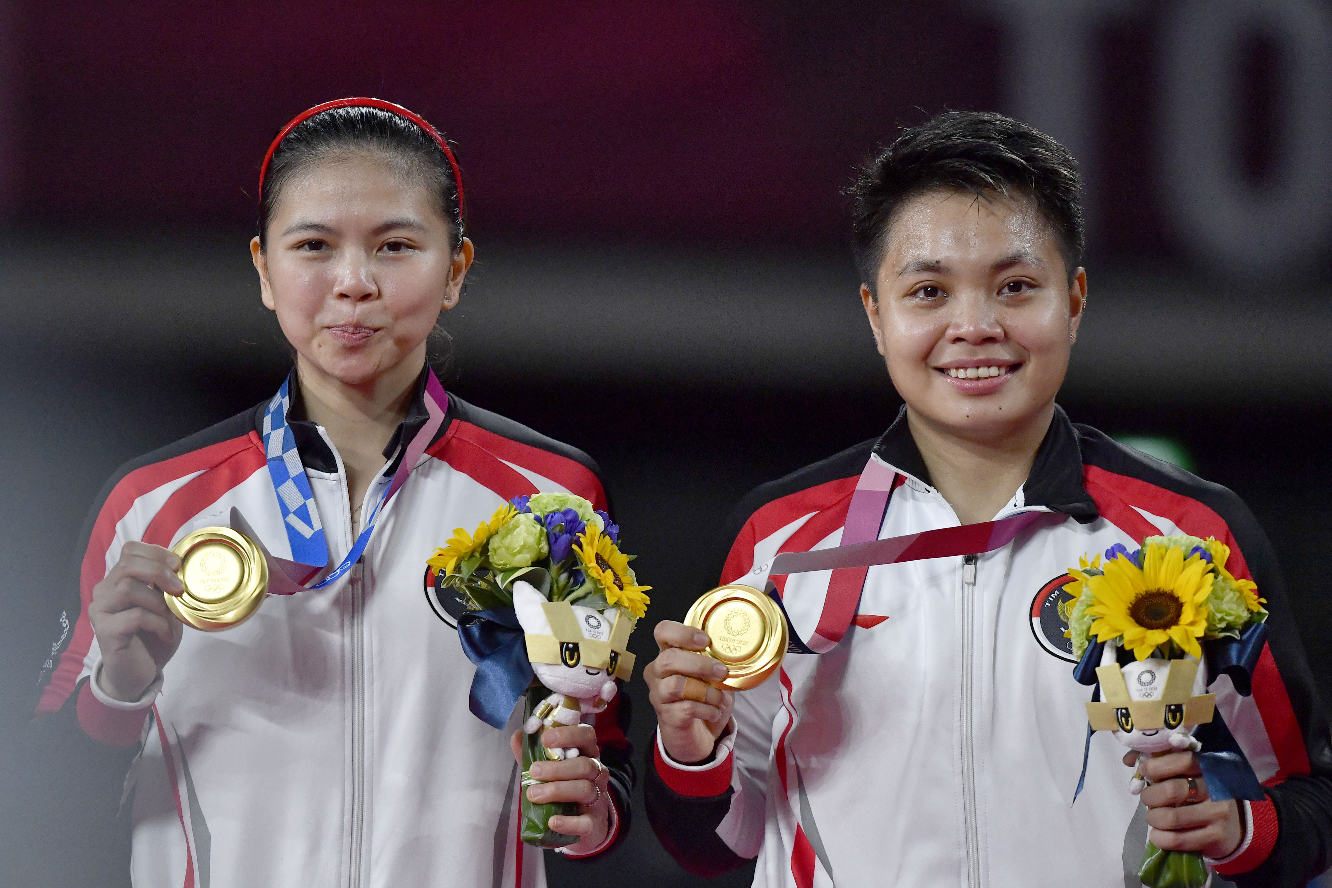 Ganda putri Greysia Polii dan Apriyani Rahayu memamerkan medali emas yang mereka menangkan di Olimpiade Tokyo 2020.