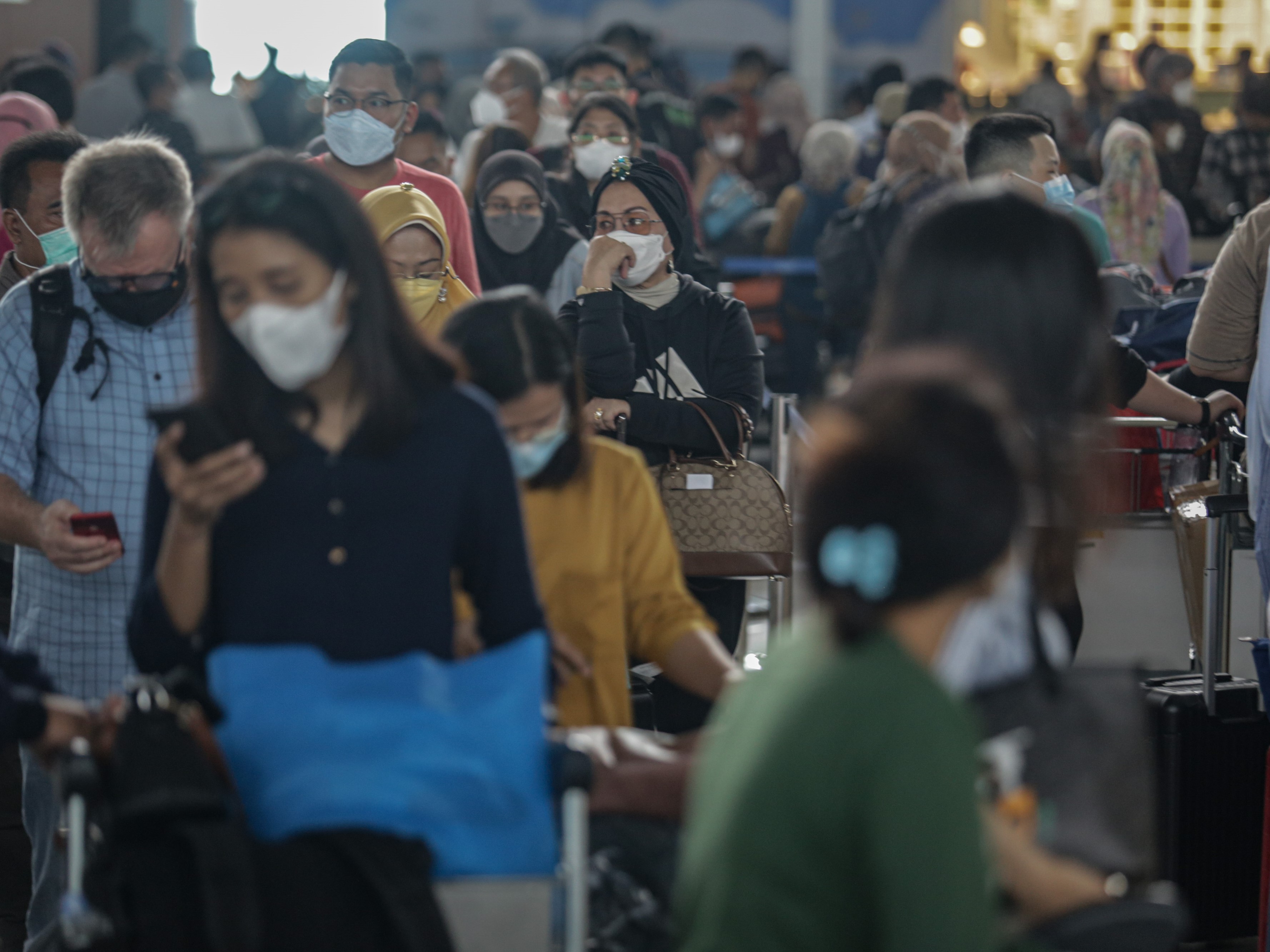 Sejumlah penumpang pesawat mengantre di loket lapor diri, area Terminal 3 Bandara Internasional Soekarno-Hatta, Jumat (17/12/2021).