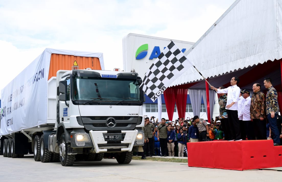 Presiden Joko Widodo mengibarkan bendera saat melepas keberangkatan truk kontainer berisi serat rayon untuk diekspor ke Turki.