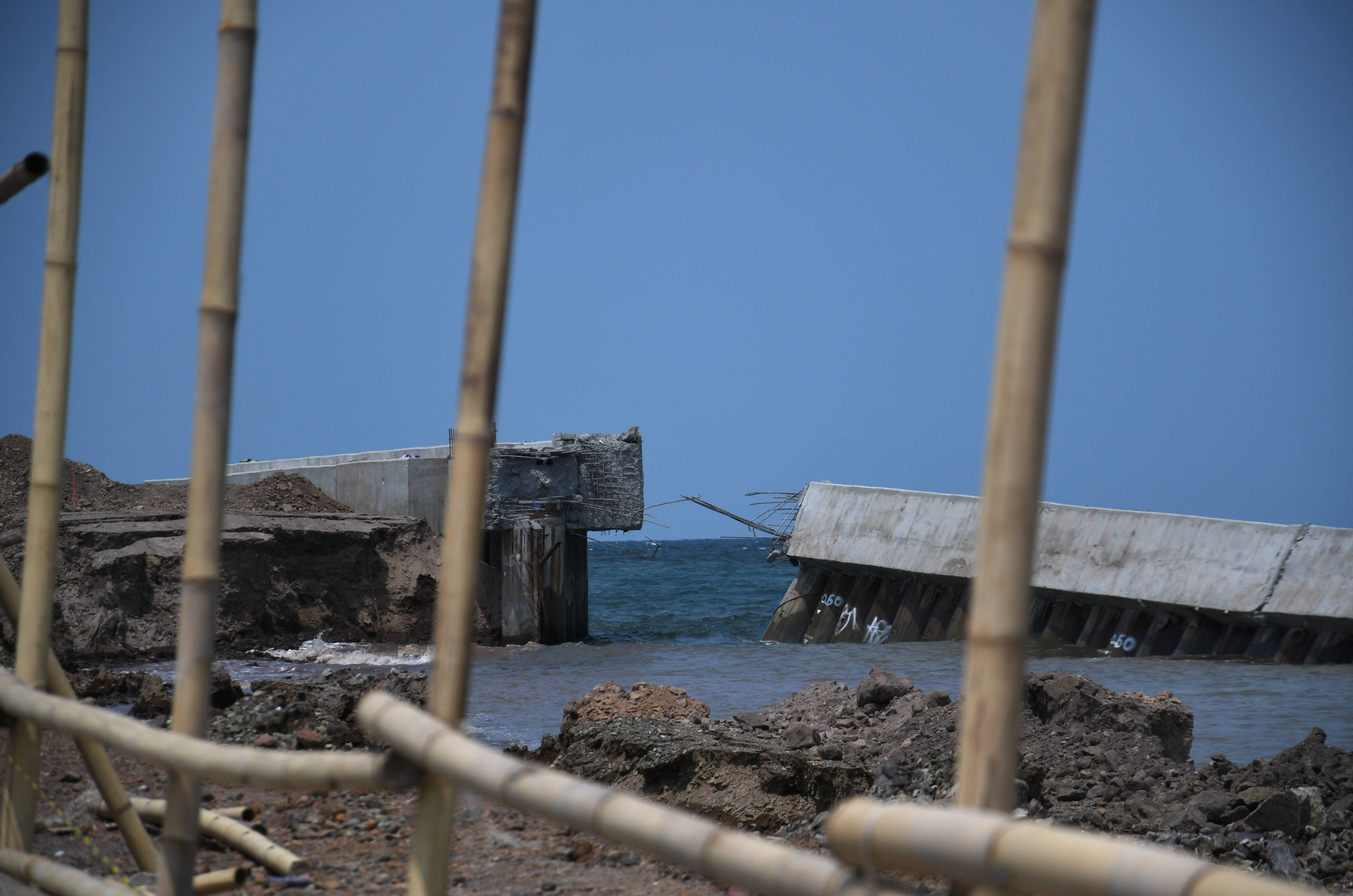 Pekerja memasang bambu dan seng untuk menutupi tanggul NCICD di Muara Baru, Jakarta Utara