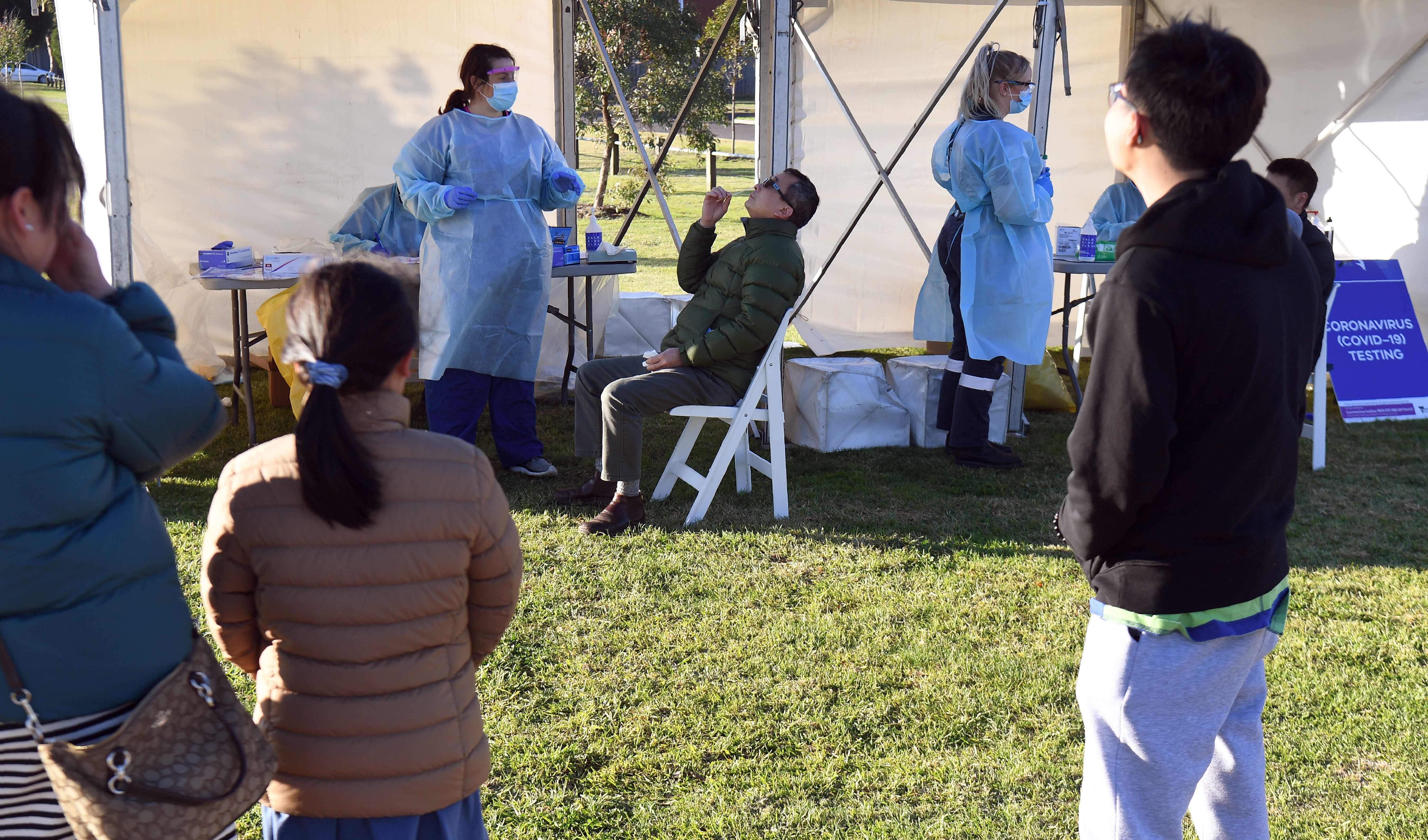 Anak-anak menyaksikan orang tua mereka yang hendak divaksin Covid-19 di Melbourne, Australia. 