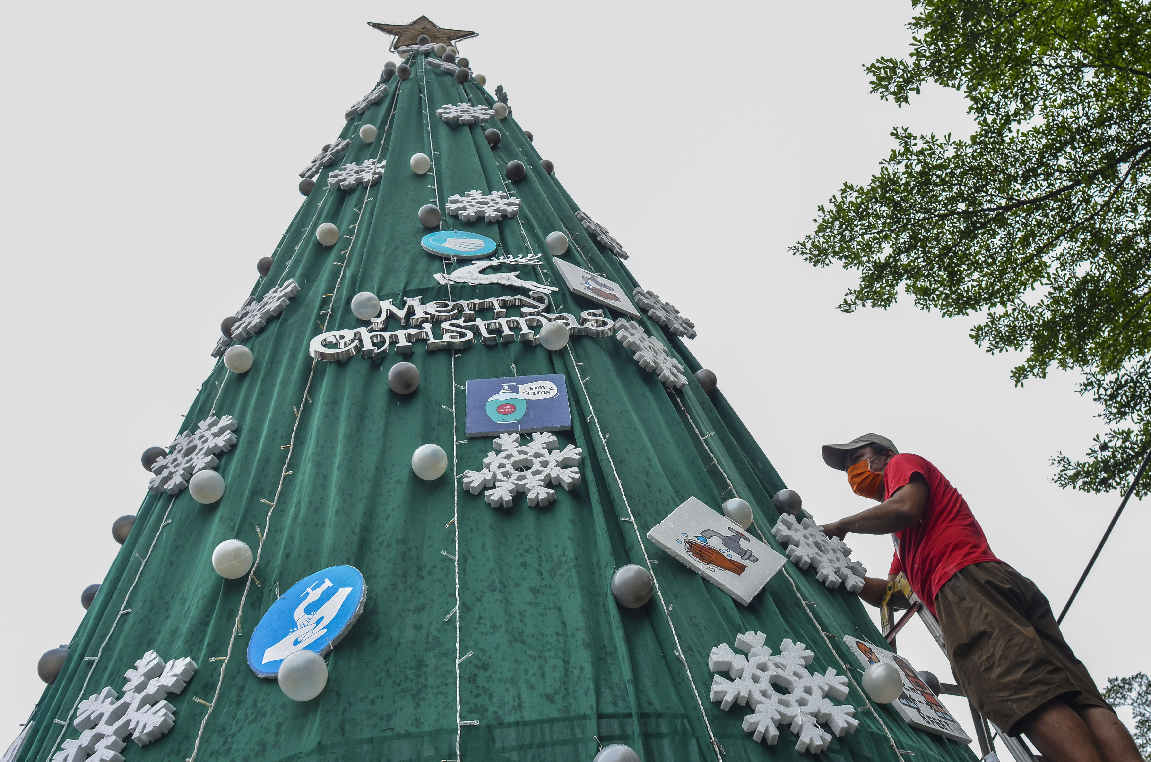 Umat Kristiani menghiasi pohon natal di Halaman Gereja Katolik Santo Yohanes, Kabupaten Ciamis, Jawa Barat