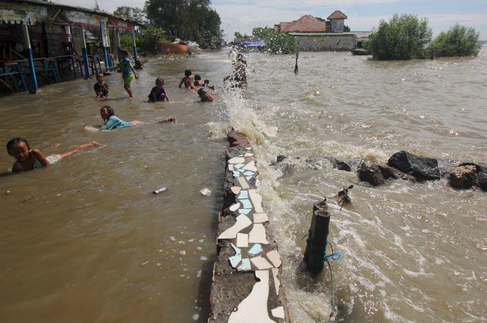 Sejumlah anak bermain genangan rob di Kenjeran Park, Surabaya, Jawa Timur, Jumat (28/5).