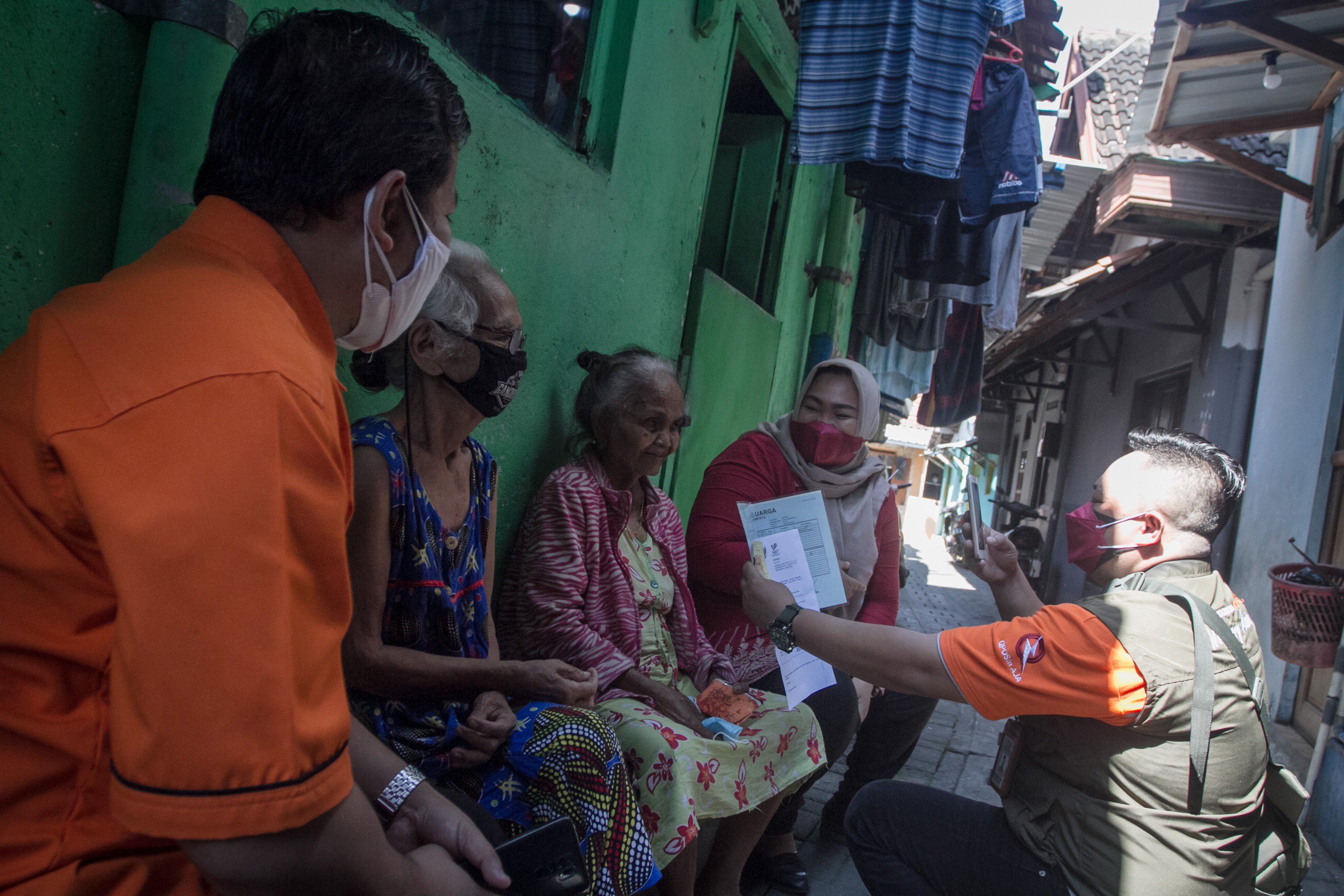 Petugas PT Pos Indonesia mendatangi rumah warga kurang mampu saat penyaluran Bantuan Langsung Tunai, di Solo, Jawa Tengah, Rabu (28/7).