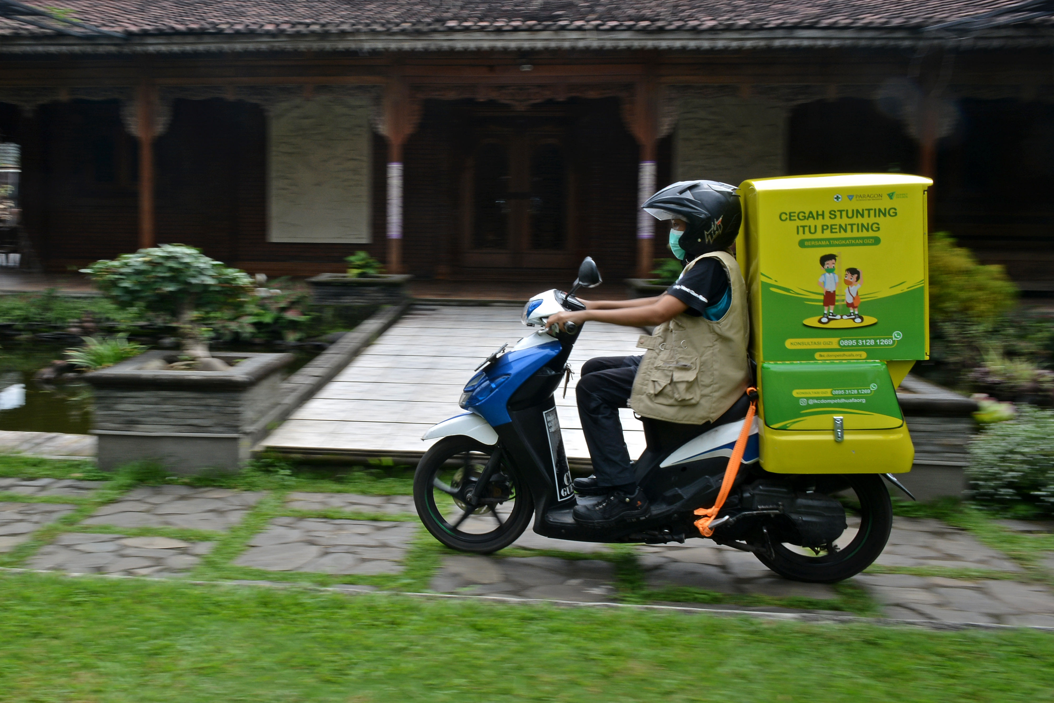   Relawan mengantarkan olahan makanan bergizi dengan Motor Gizi Makanan Sarat Gizi (Mozi Masagi) di Tarogong Kidul, Kabupaten Garut