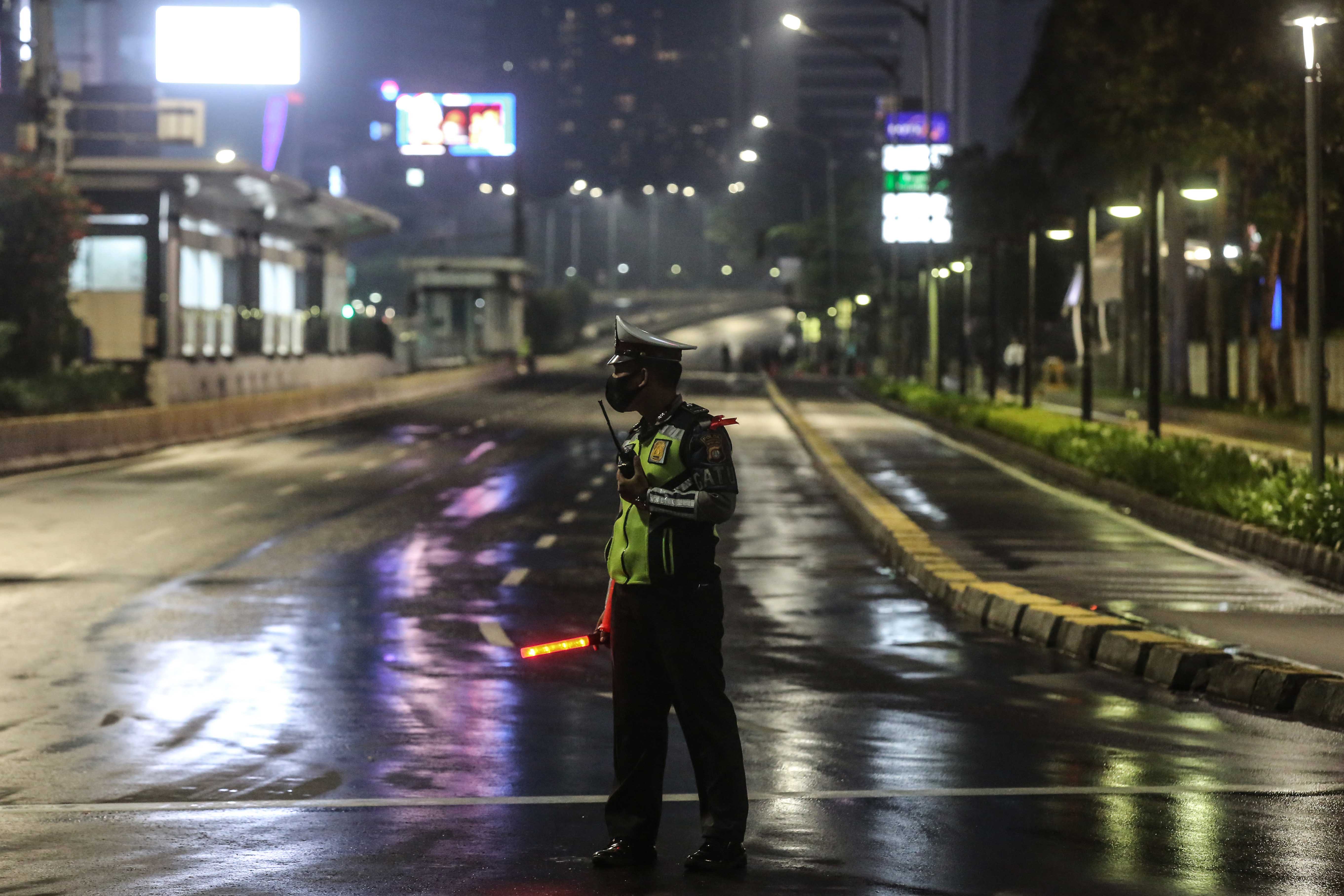Petugas berjaga saat diberlakukannya Car Free Night (malam bebas kendaraan) dan Crowd Free Night (malam bebas keramaian) pada mala