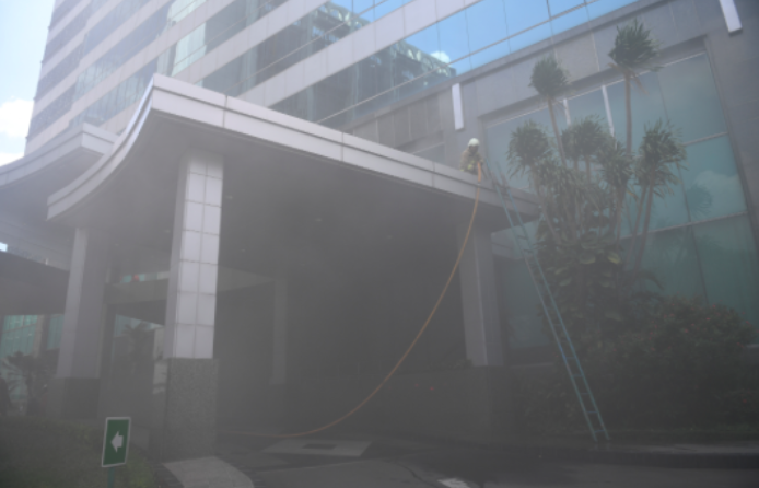Petugas menerobos asap tebal saat berusaha memadamkan kebakaran yang terjadi di Gedung Cyber 1, Jakarta, Kamis (2/12/2021).