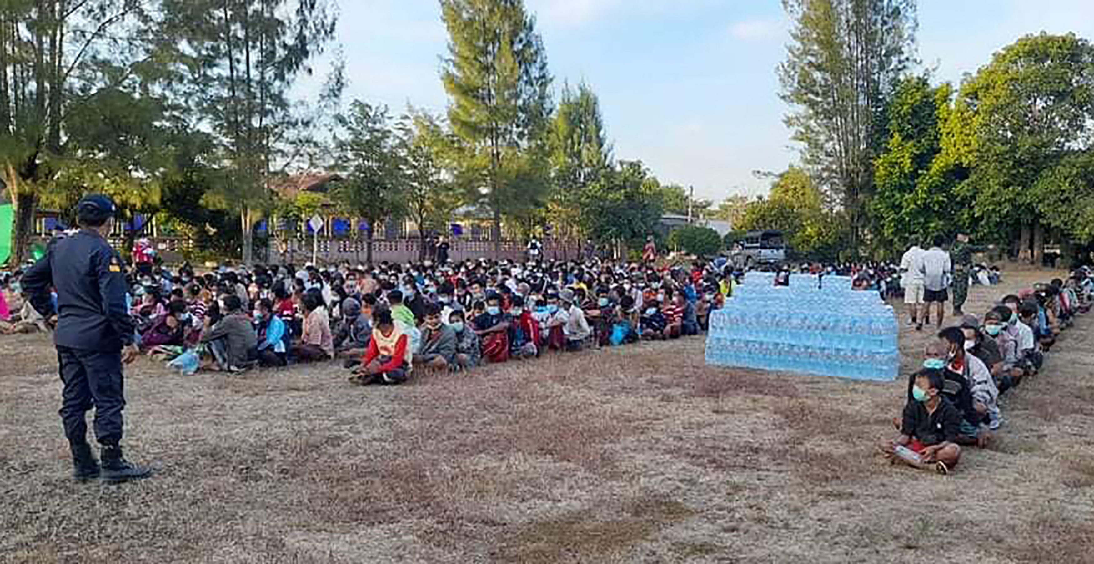 Ribuan pengungsi asal Myanmar duduk berbaris diawasi tentara Thailand di  Mae Tao Phae, Distrik Mae Sot, Thailand, Kamis (16/12).   