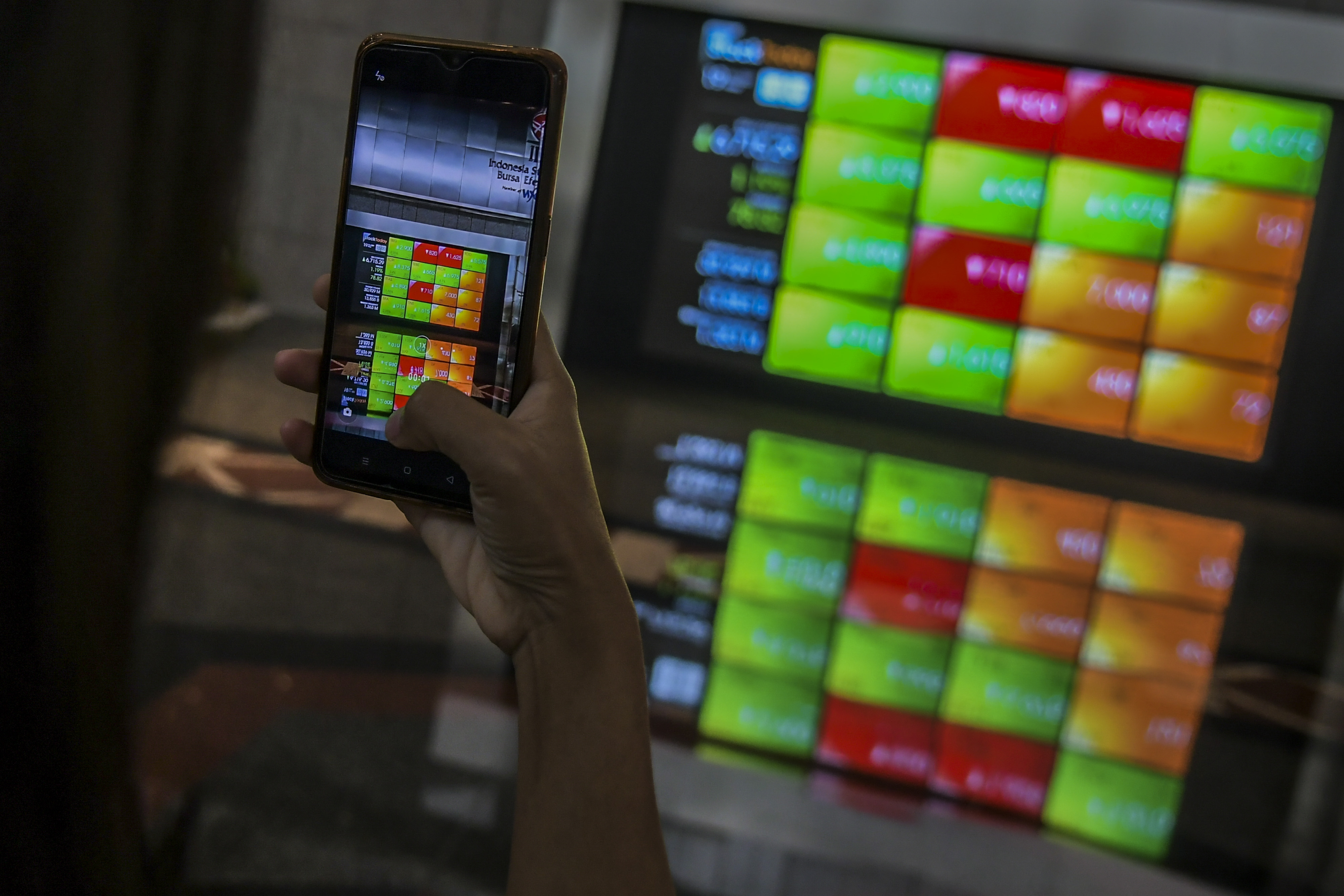 Karyawan memotret layar pergerakan Indeks Harga Saham Gabungan (IHSG) di gedung Bursa Efek Indonesia, Jakarta, Jumat (19/11).