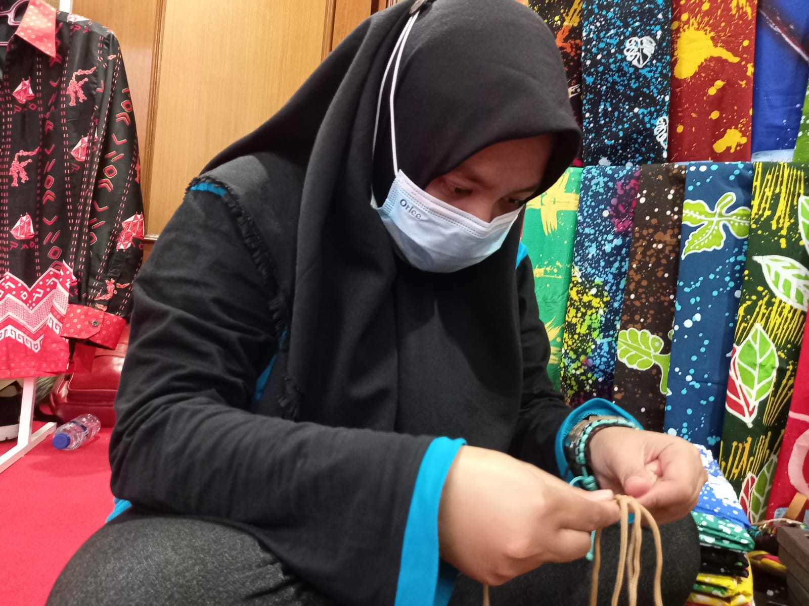 Penyandang disabilitas Dini Defitri menunjukkan keahliannya merangkai tali kur di Pameran Hari Disabilitas Internasional 2021 di Jakarta.