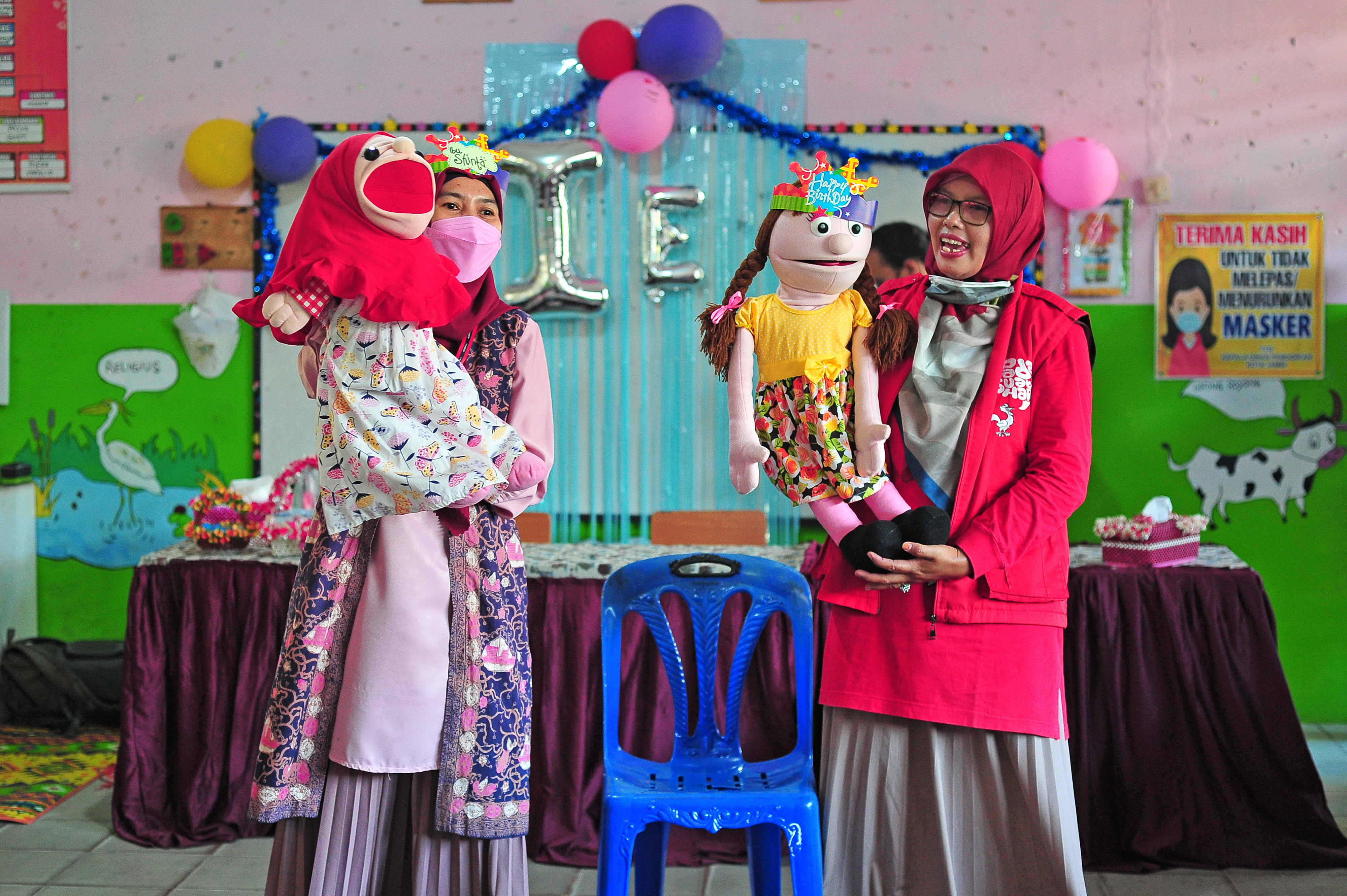 Anggota komunitas Kampung Dongeng Indonesia mendongeng di hadapan murid kelas 1 SDN 28 Kota Jambi saat kegiatan imunisasi campak di Jambi.