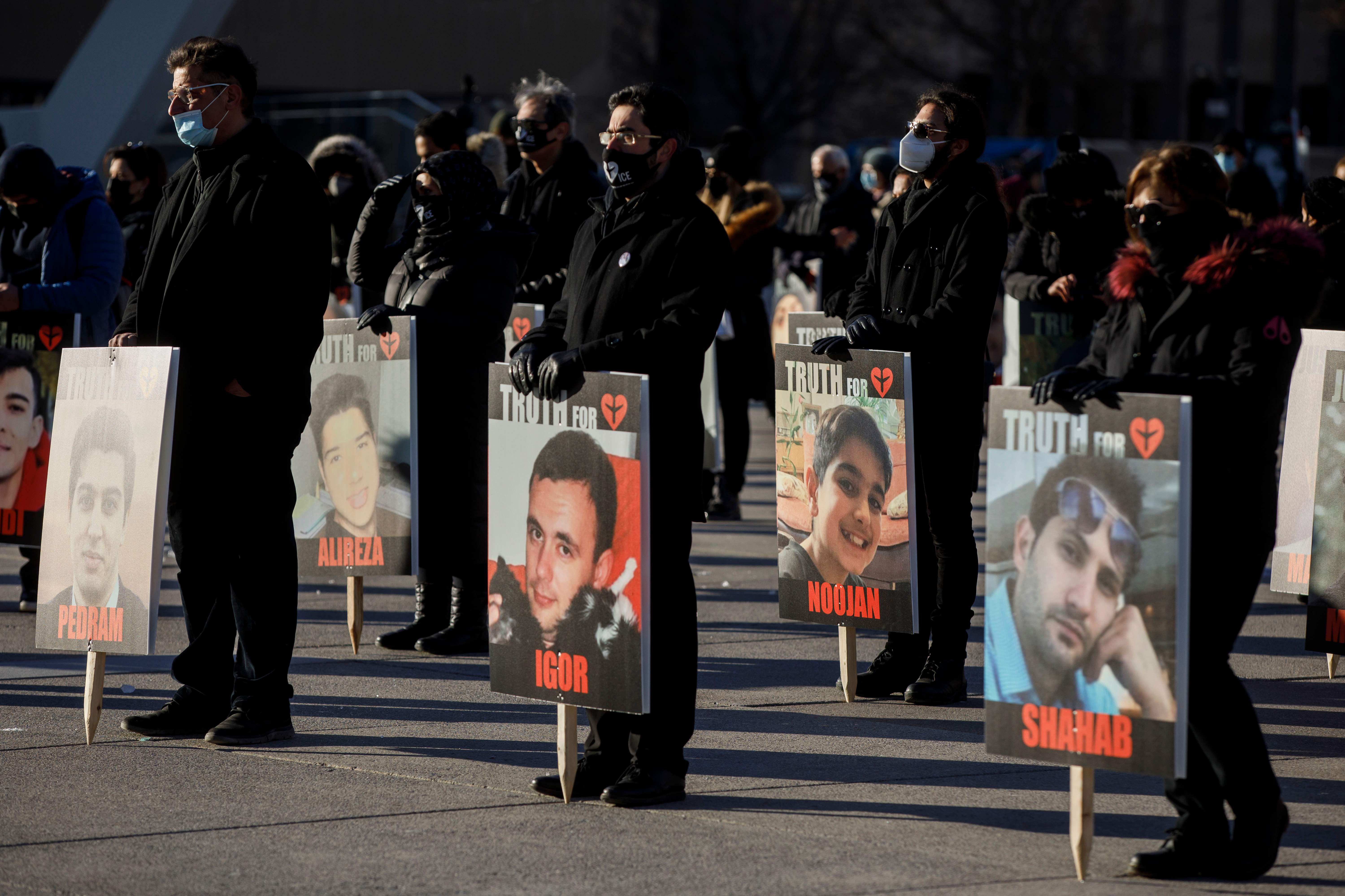 Warga memegang foto orang-orang yang tewas setelah pesawat Ukraine International Airlies ditembak jatuh militer Iran.