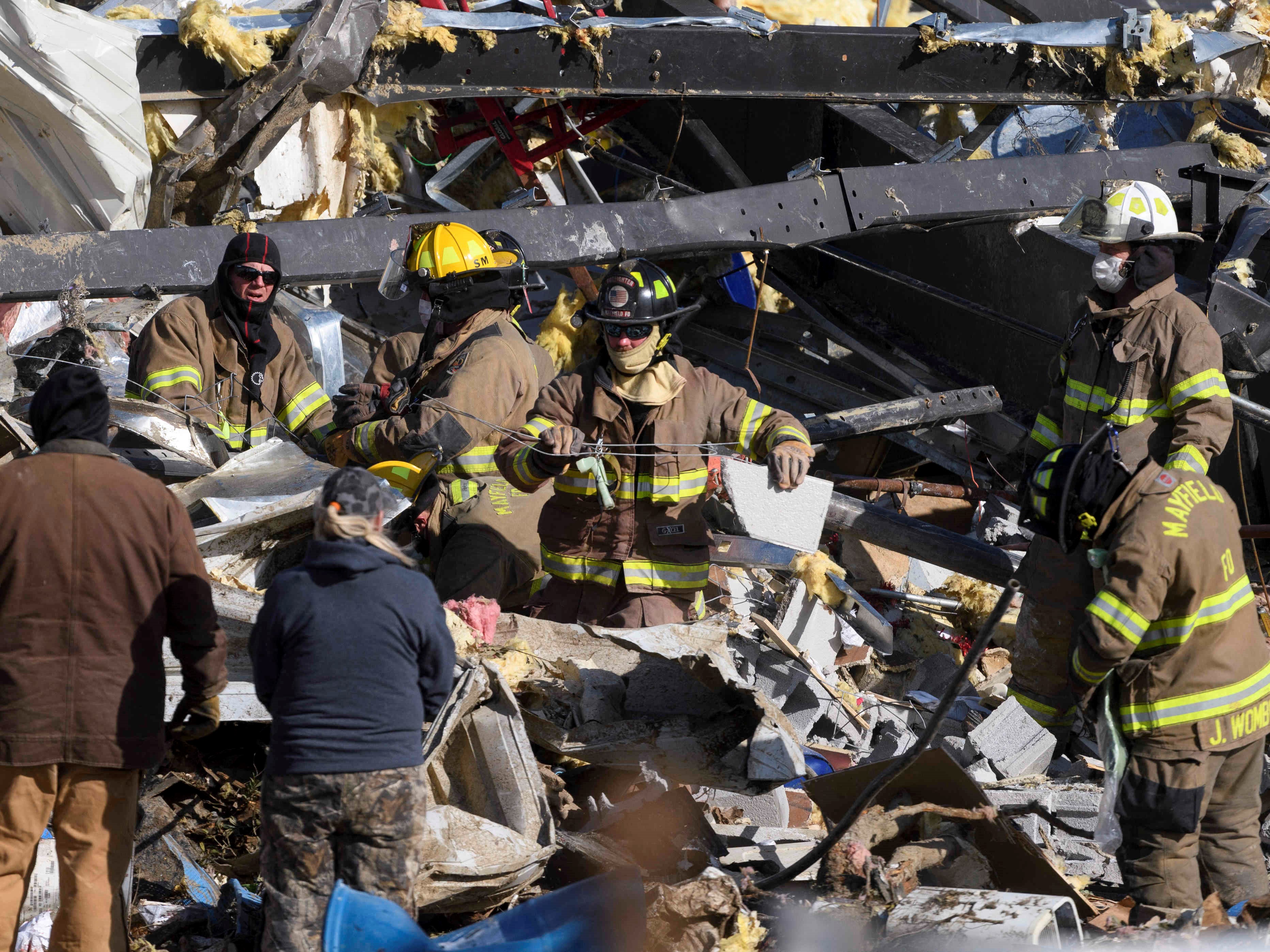 Pekerja darurat mencari melalui yang tersisa dari pabrik lilin setelah dihancurkan oleh tornado di Mayfield, Kentucky, 11 Desember 2021.