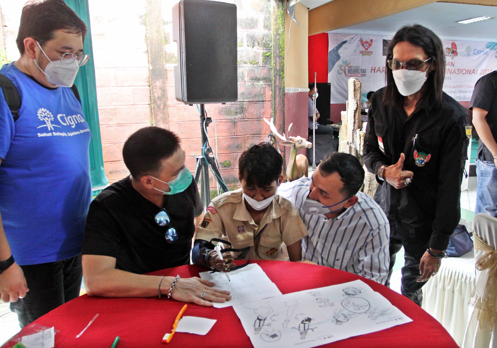 Rian (tengah) sedang mencoba menggunakan tangan palsu bantuan Cigna Indonesia, Jumat (3/12).