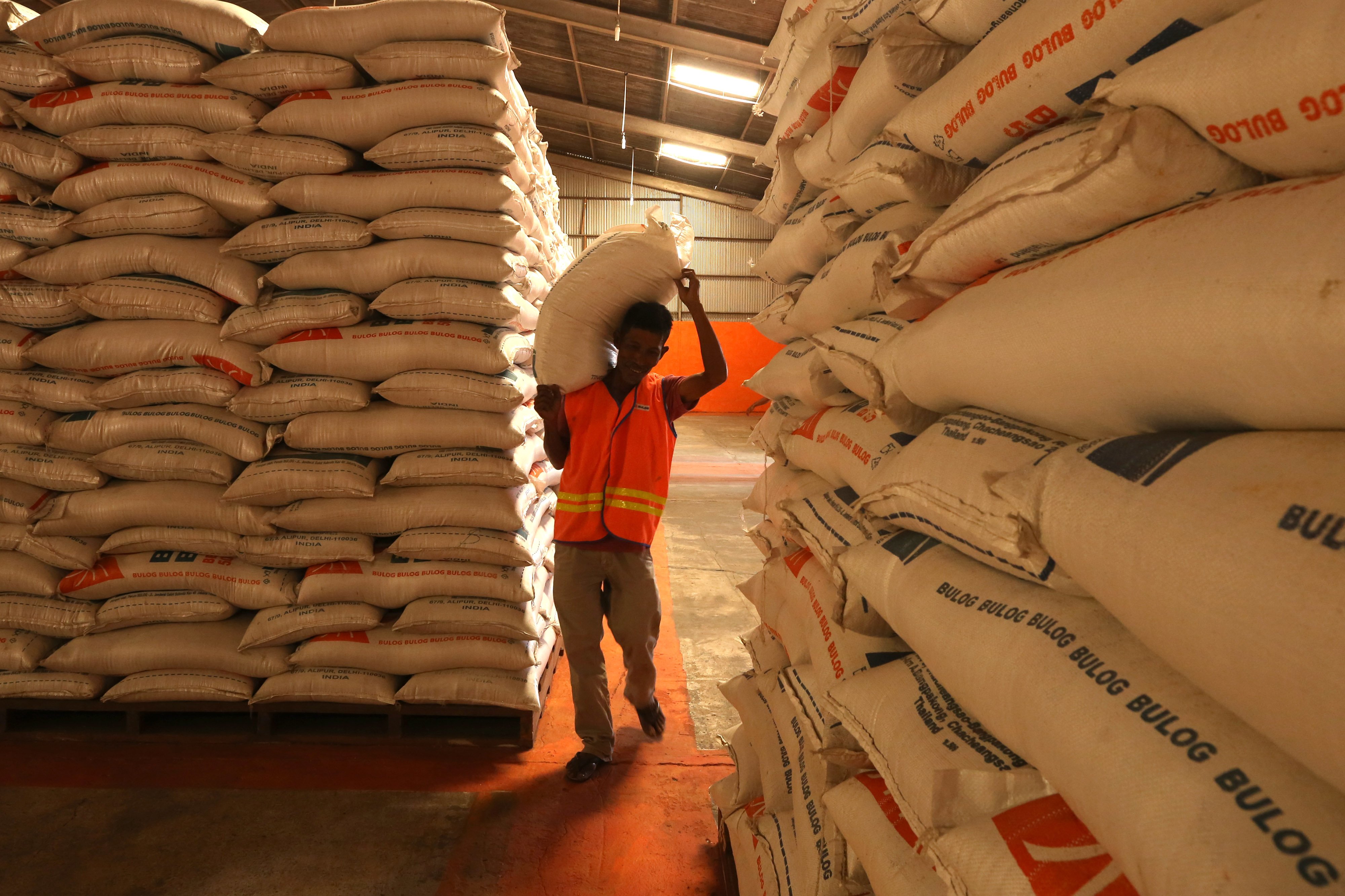 Pekerja mengangkut beras stok Bulog di gudang penyimpanan Siron, Aceh Besar, Aceh, Rabu (1/9/2021).
