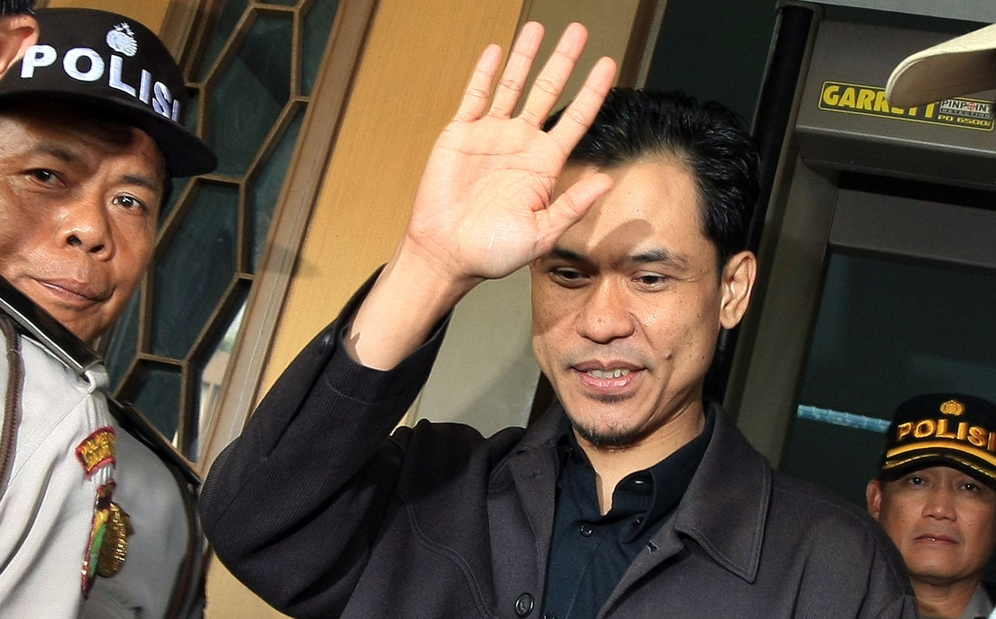 Munarman melambaikan tangan kepada wartawan saat mengikuti sidang HRS beberapa waktu lalu.