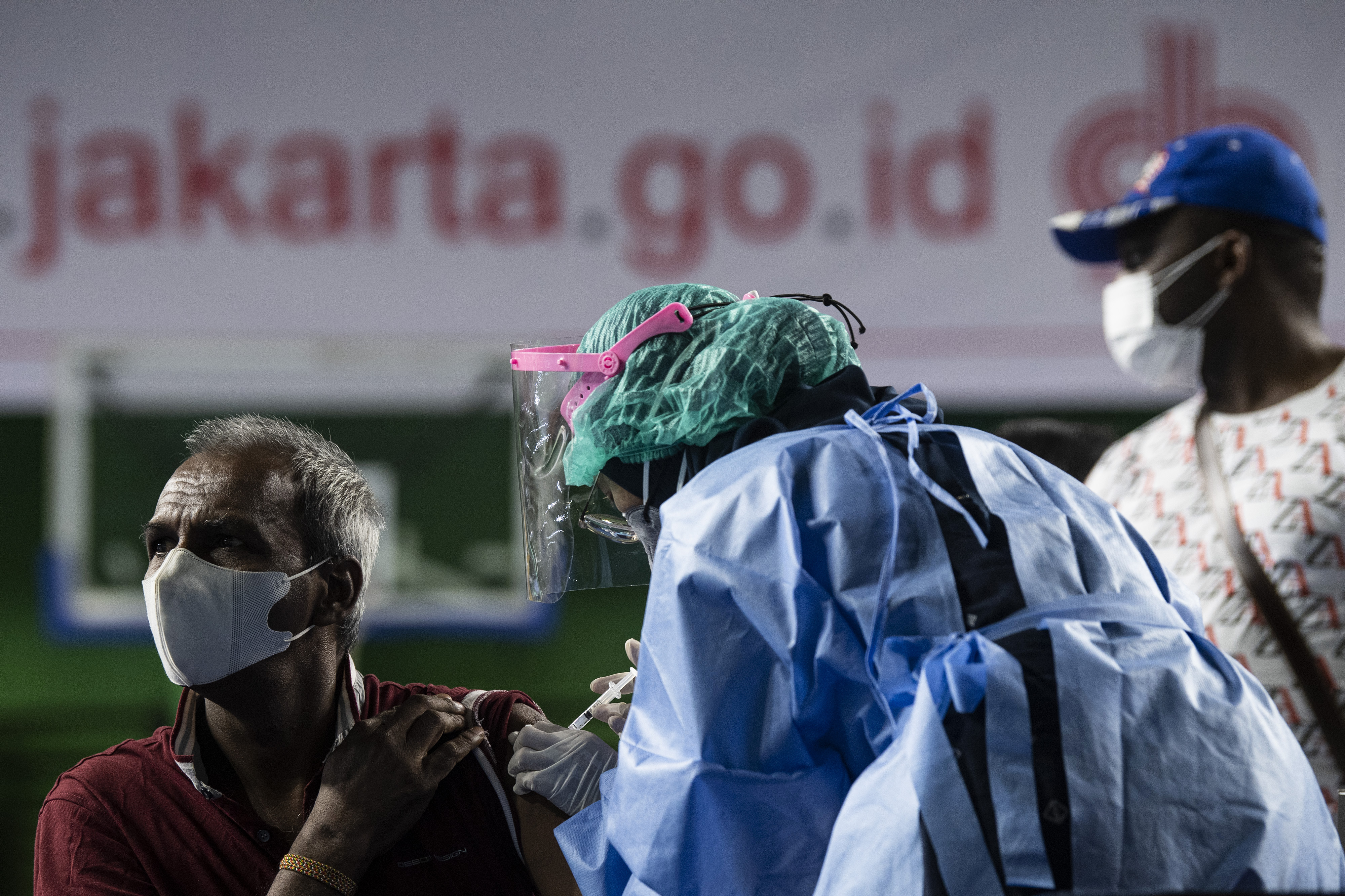 Seorang pencari suaka mendapatkan vaksinasi COVID-19 Sinopharm di GOR Bulungan, Kebayoran Baru, Jakarta Selatan, Kamis (7/10/2021). 