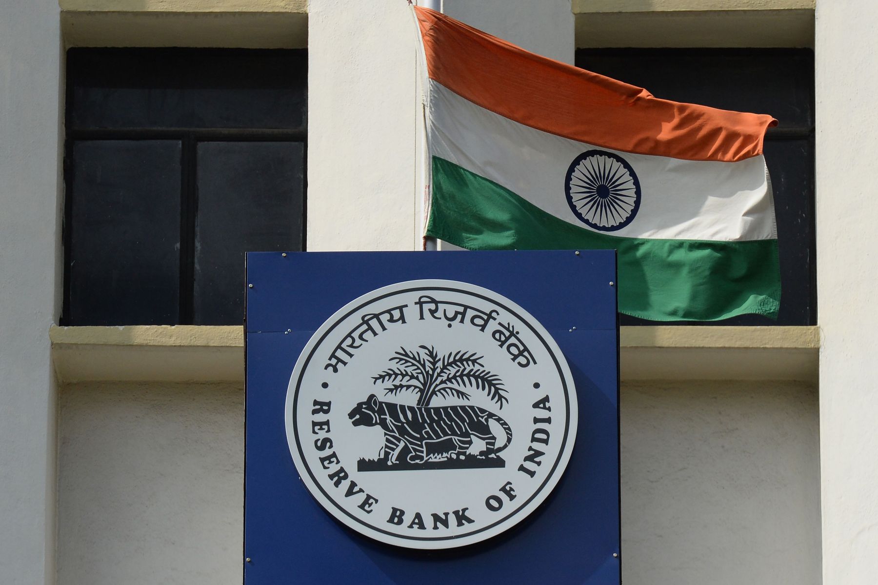 Logo Bank Sentral India yang disertai dengan Bendera Kebangsaan India.  