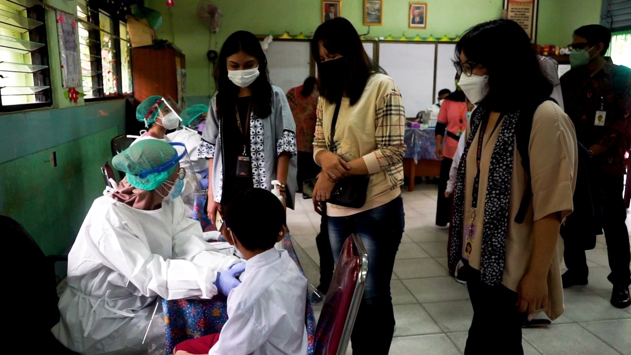 Seorang tenaga kesehatan tengah bersiap melakukan vaksin untuk anak SD.