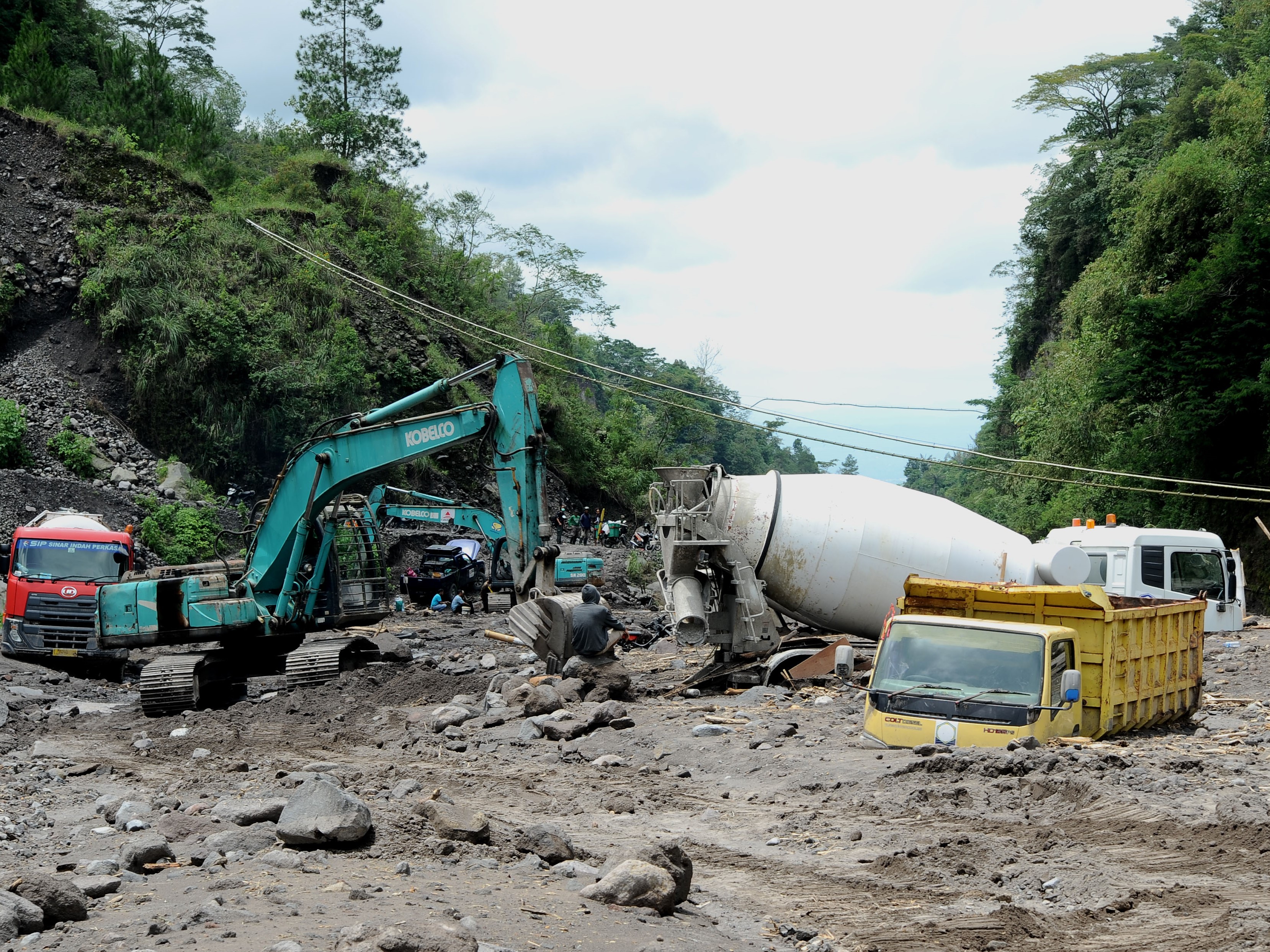Pekerja menggunakan ekskavator mengevakuasi truk yang terjebak lahar hujan di aliran sungai Senowo kawasan lereng Gunung Merapi Dusun Trono.