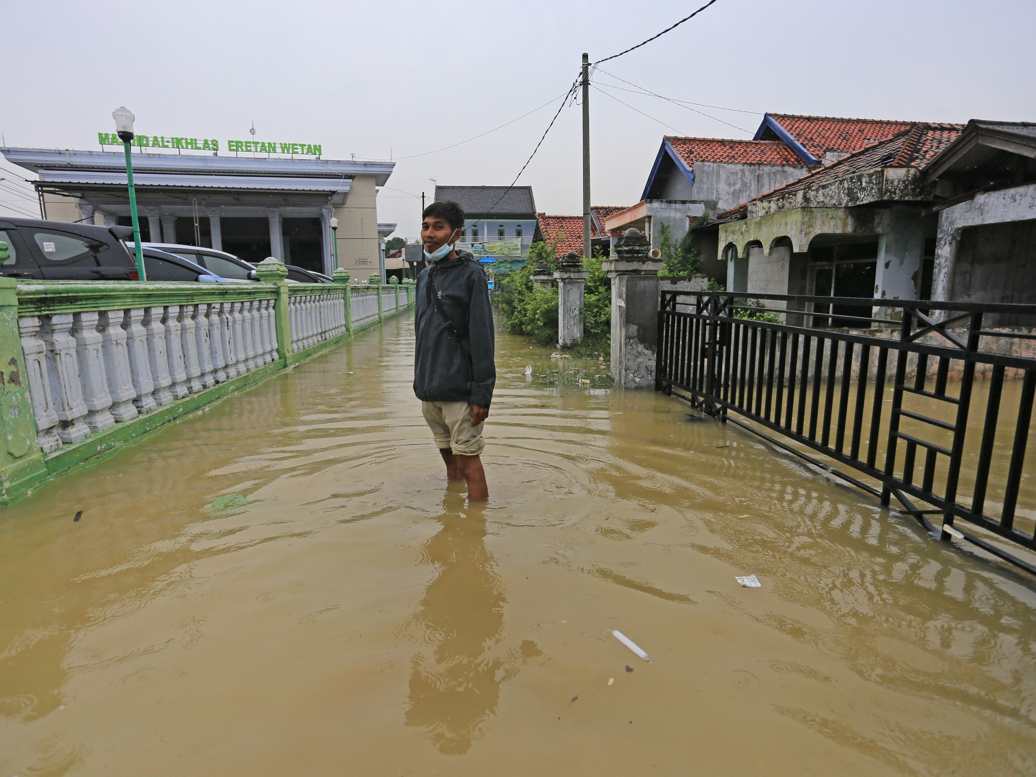 Warga berdiri di jalanan yang terendam banjir rob di desa Eretan Wetan, Kandanghaur, Indramayu, Jawa Barat, Sabtu (4/12/2021).