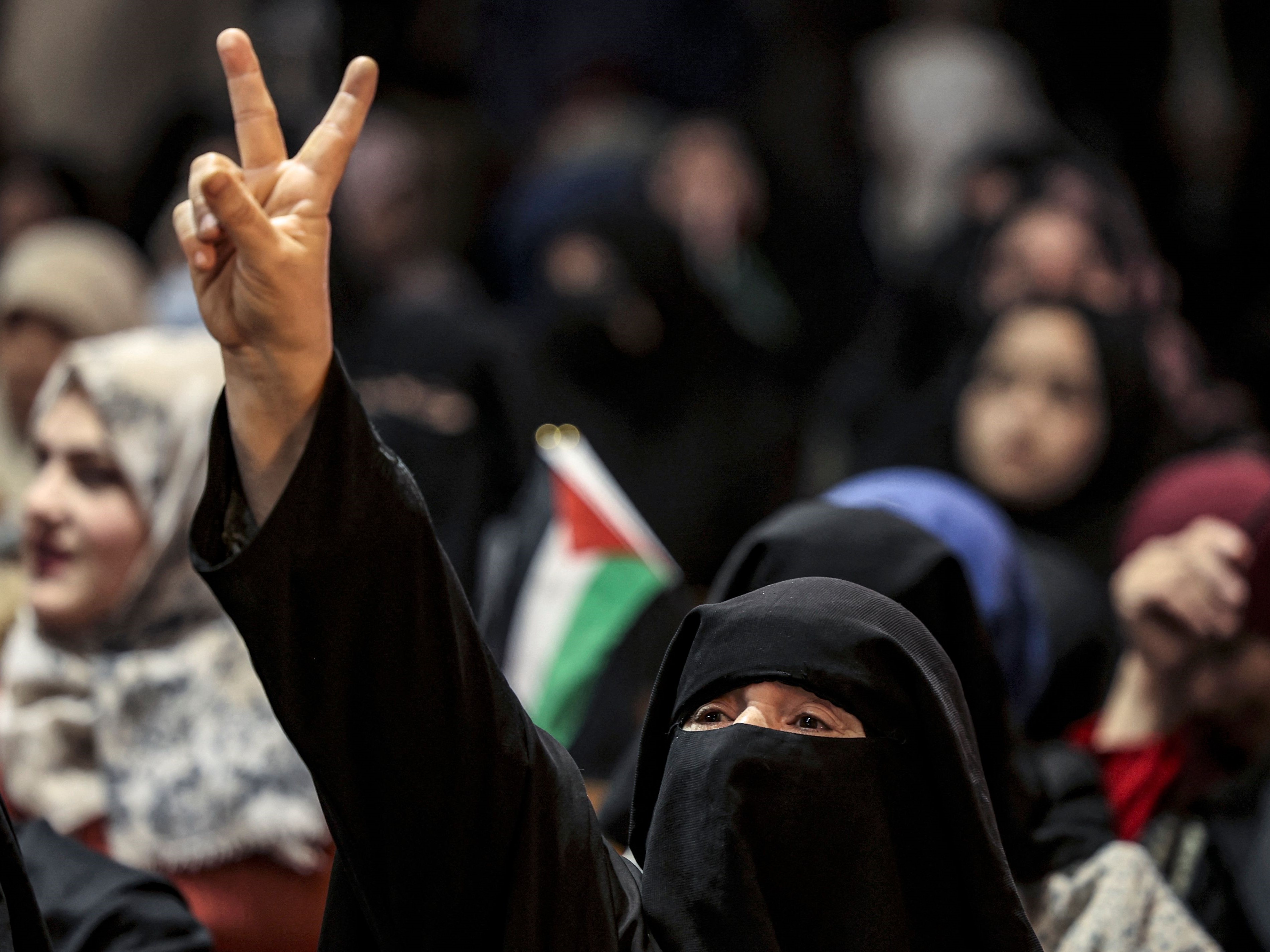 Seorang wanita mengacungkan dua jari menentang kemungkinan penunjukan Inggris atas Hamas sebagai kelompok teroris.