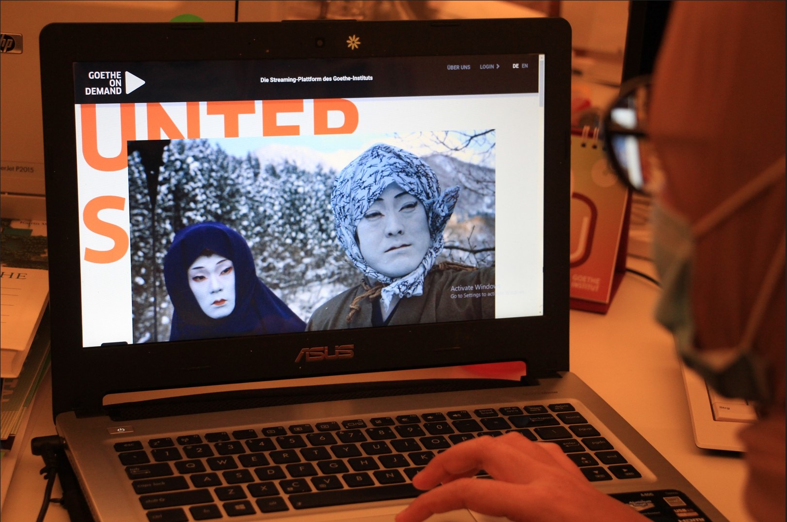 Seorang warga menonton German Cinema di laptop.