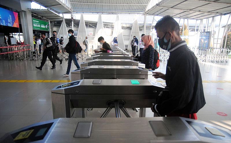 Ilustrasi - Penumpang KRL Commuterline menggunakan masker ganda dan berjalan di gerbang tiket elektronik Stasiun Bogor, Jawa Bara.