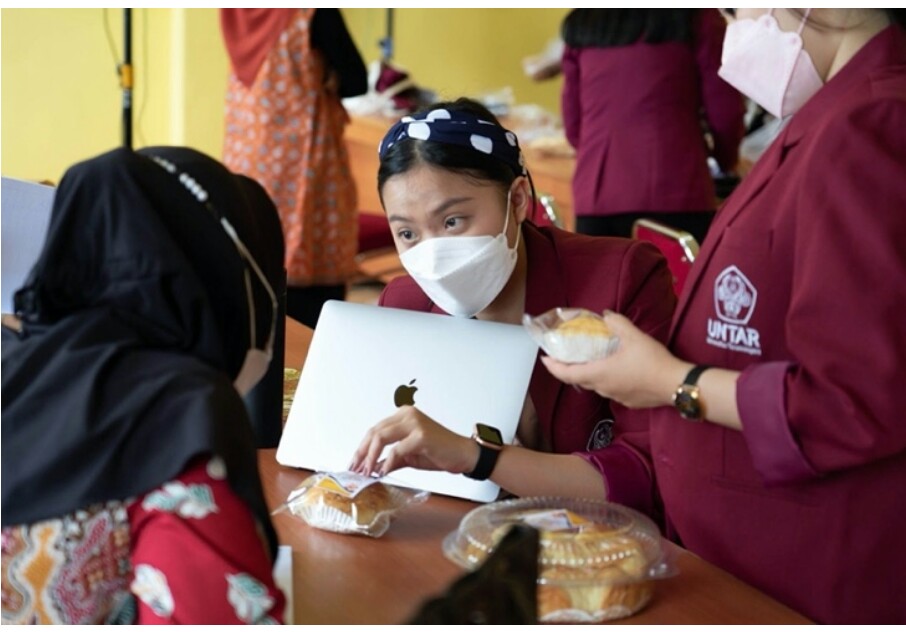 Mahasiswa Universitas Tarumanegara saat memberikan pendampingan kepada pelaku UMKM dalam kegiatan pengabdian kepada masyarakat.