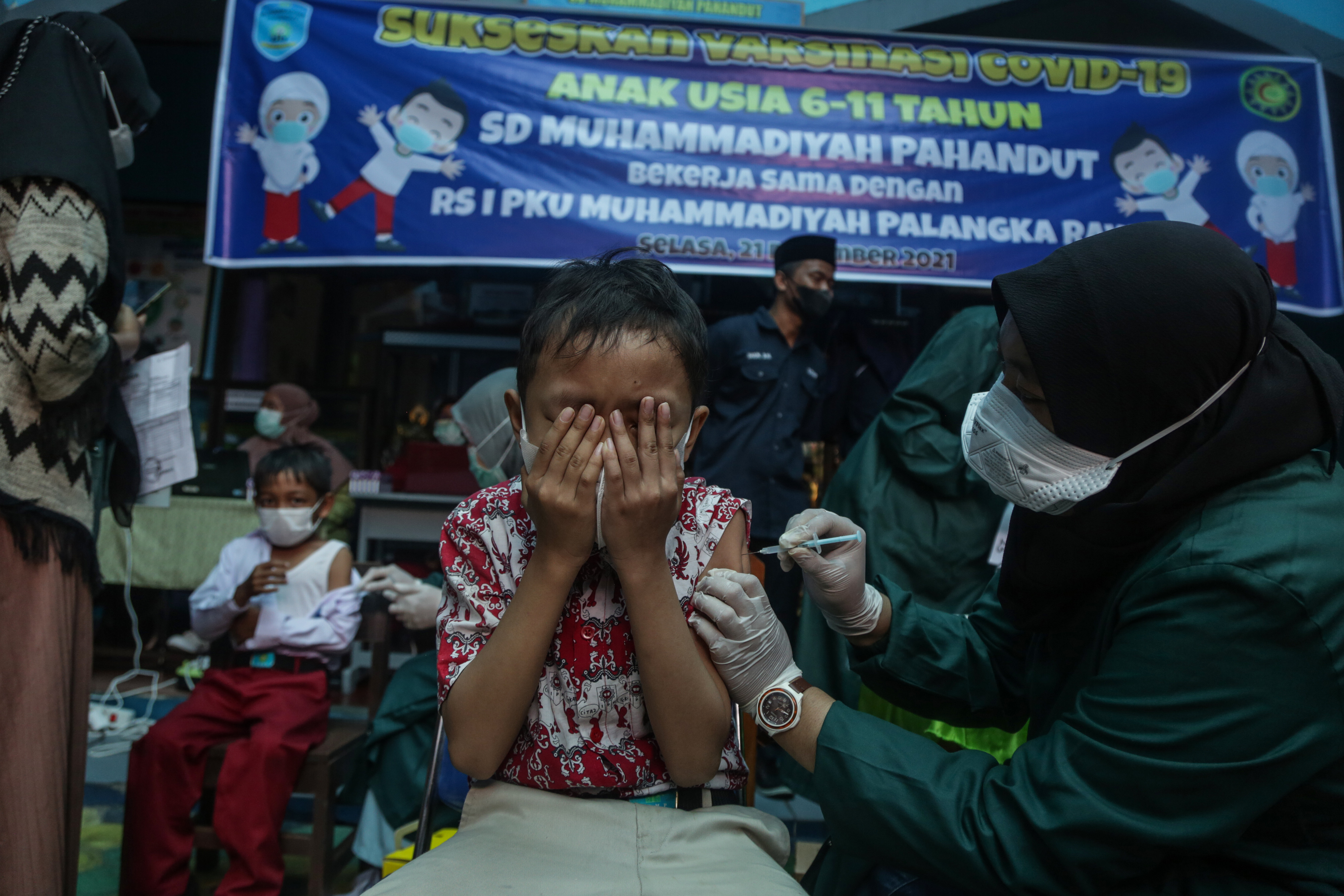 Petugas medis menyuntikkan vaksin covid-19 dosis pertama kepada siswa di SD Muhammadiyah Pahandut, Palangkaraya, Kalimantan Tengah.