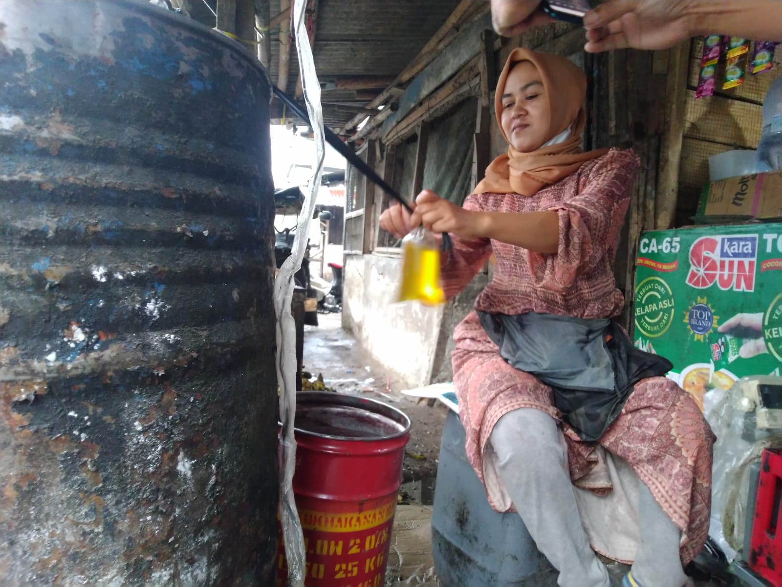 Pedagang eceran mengemas minyak goreng curah di pasar tradisional Tasikmalaya, Kamis (10/11/2021)