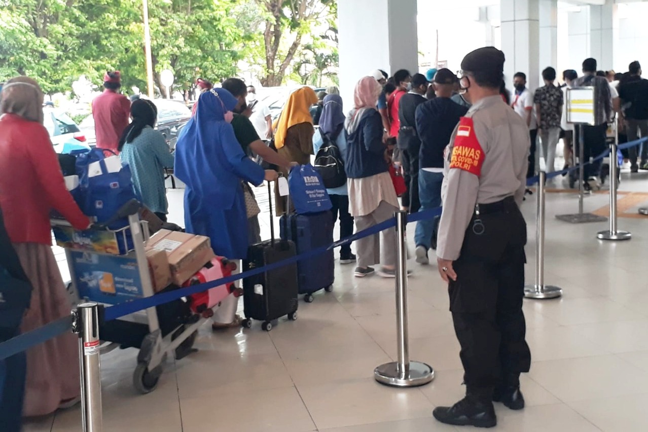  Personel Polsek Udara Polresta Denpasar berjaga mengantisipasi pelanggaran prokes di Bandara I Gusti Ngurah Rai, Selasa (7/12).