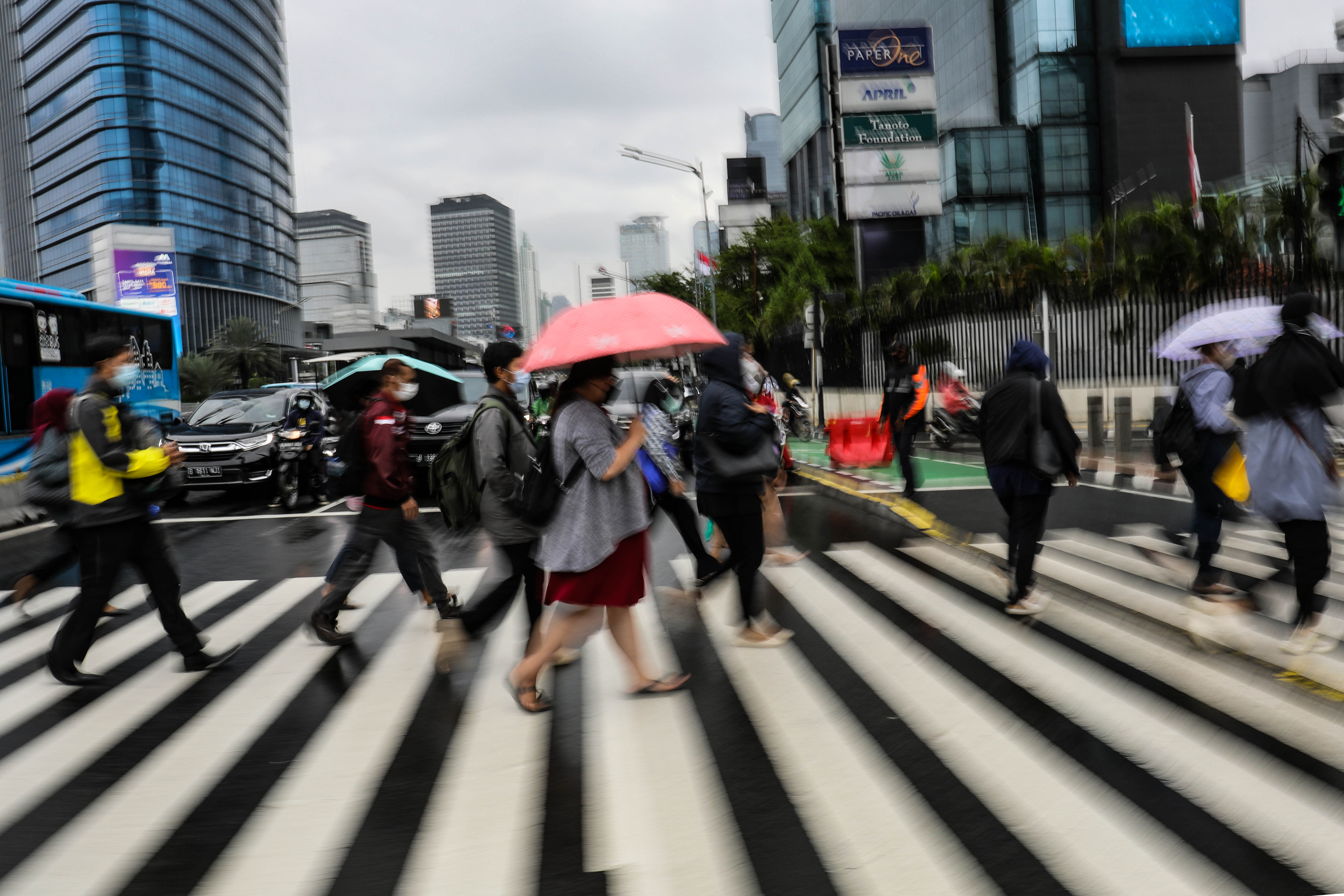 Pekerja menyeberang jalan di kawasan Sudirman, Jakarta