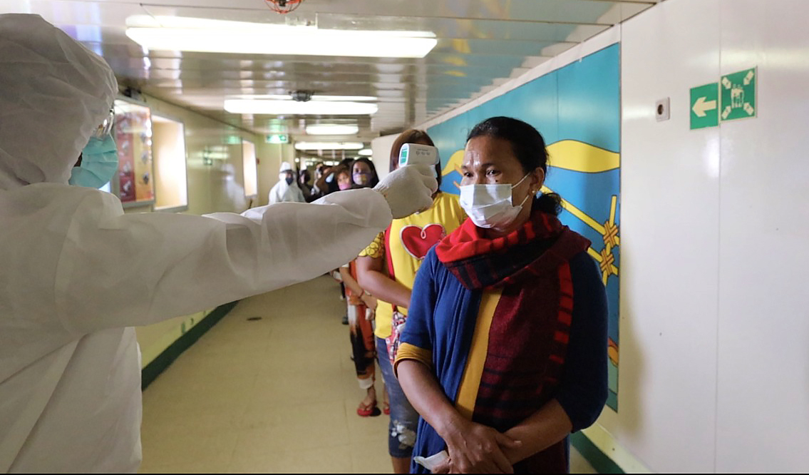 Petugas melakukan cek suhu tubuh para penumpang KM Kelud di Jakarta, kemarin. PT Pelni kembali mengoperasikan 26 kapal penumpang di s