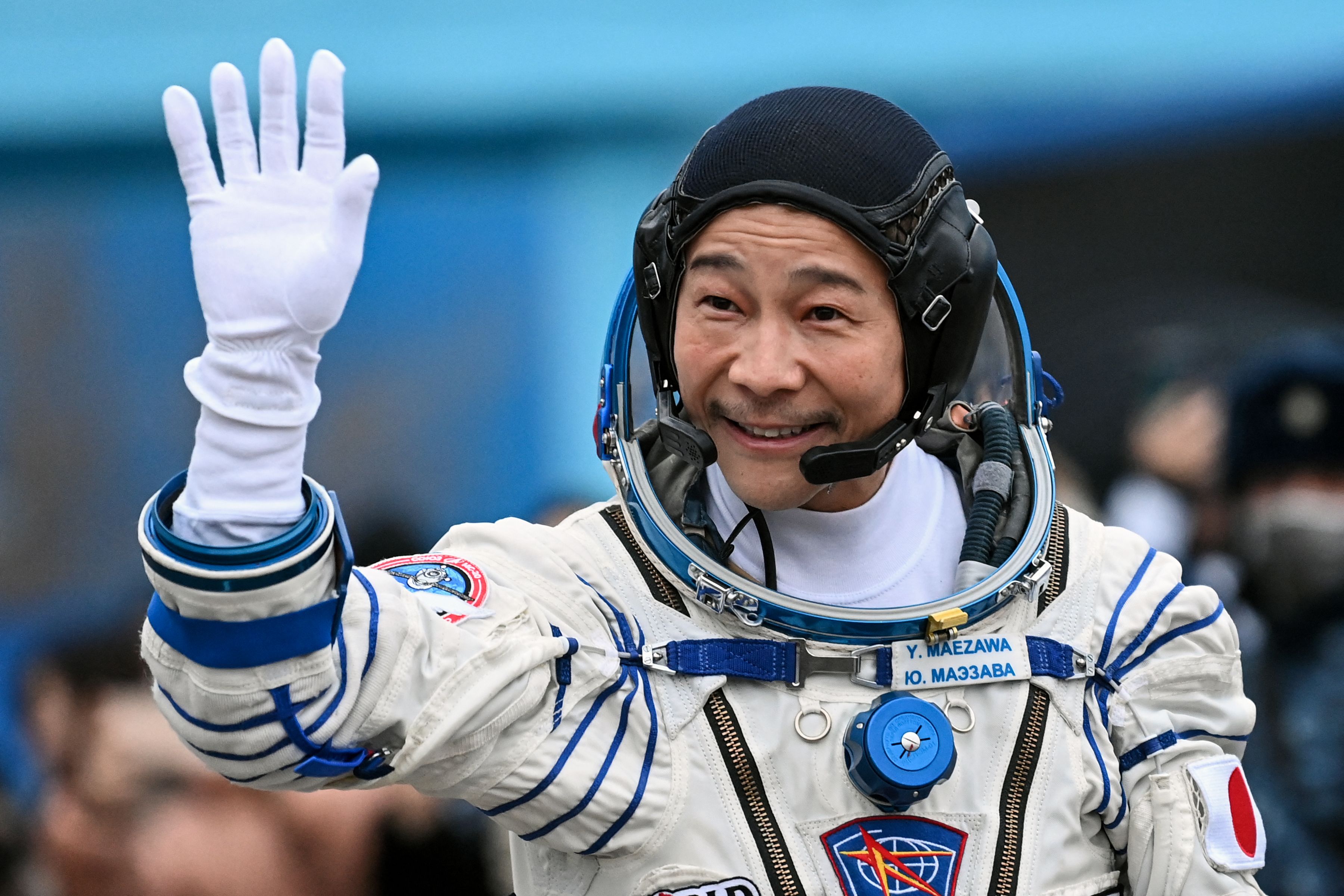 Miliarder Jepang Yusaku Maezawa melambaikan tangan sebelum bertolak ke ISS.
