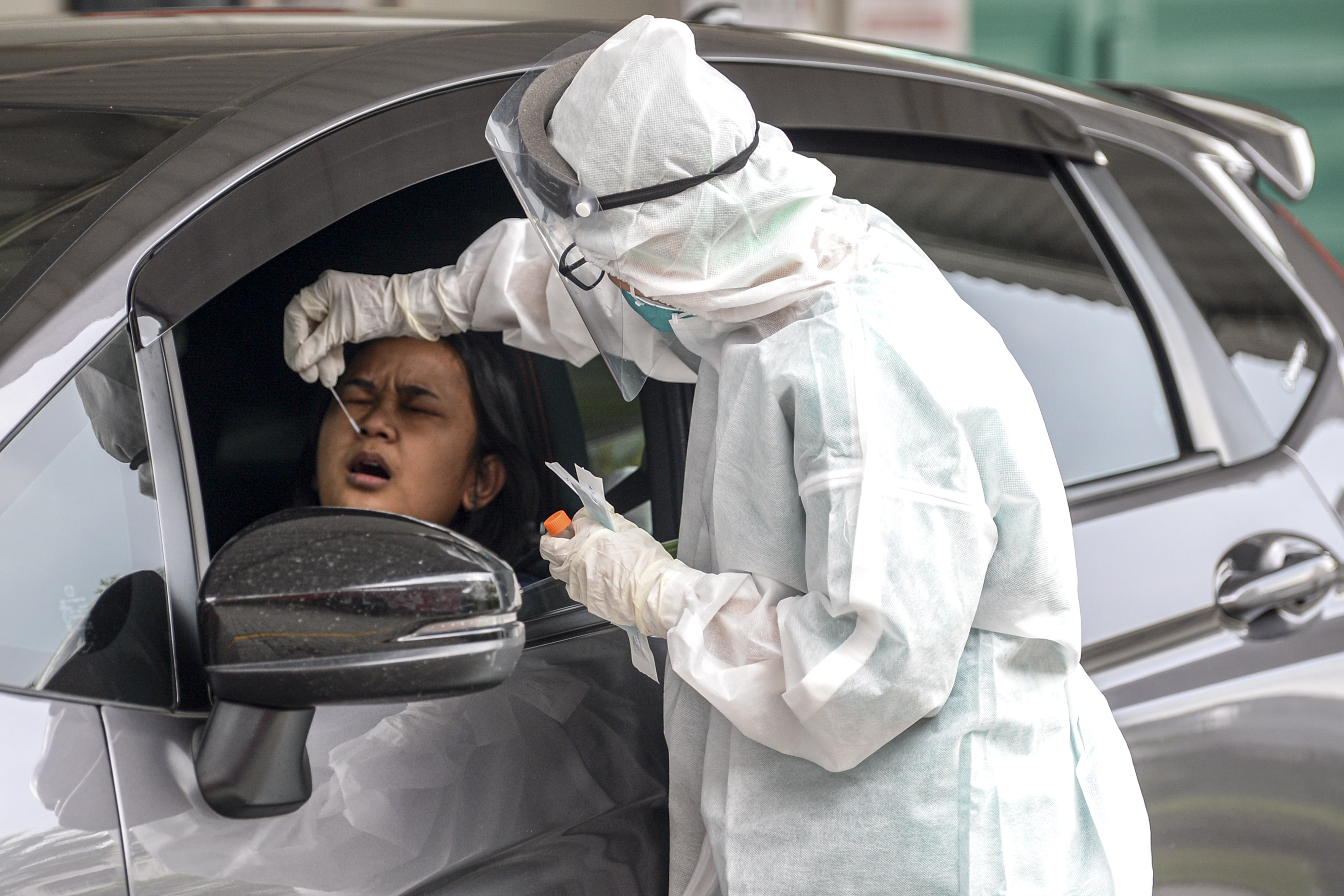 Peetugas melakukan tes Covid-19 kepada warga Jakarta secara drive-thru