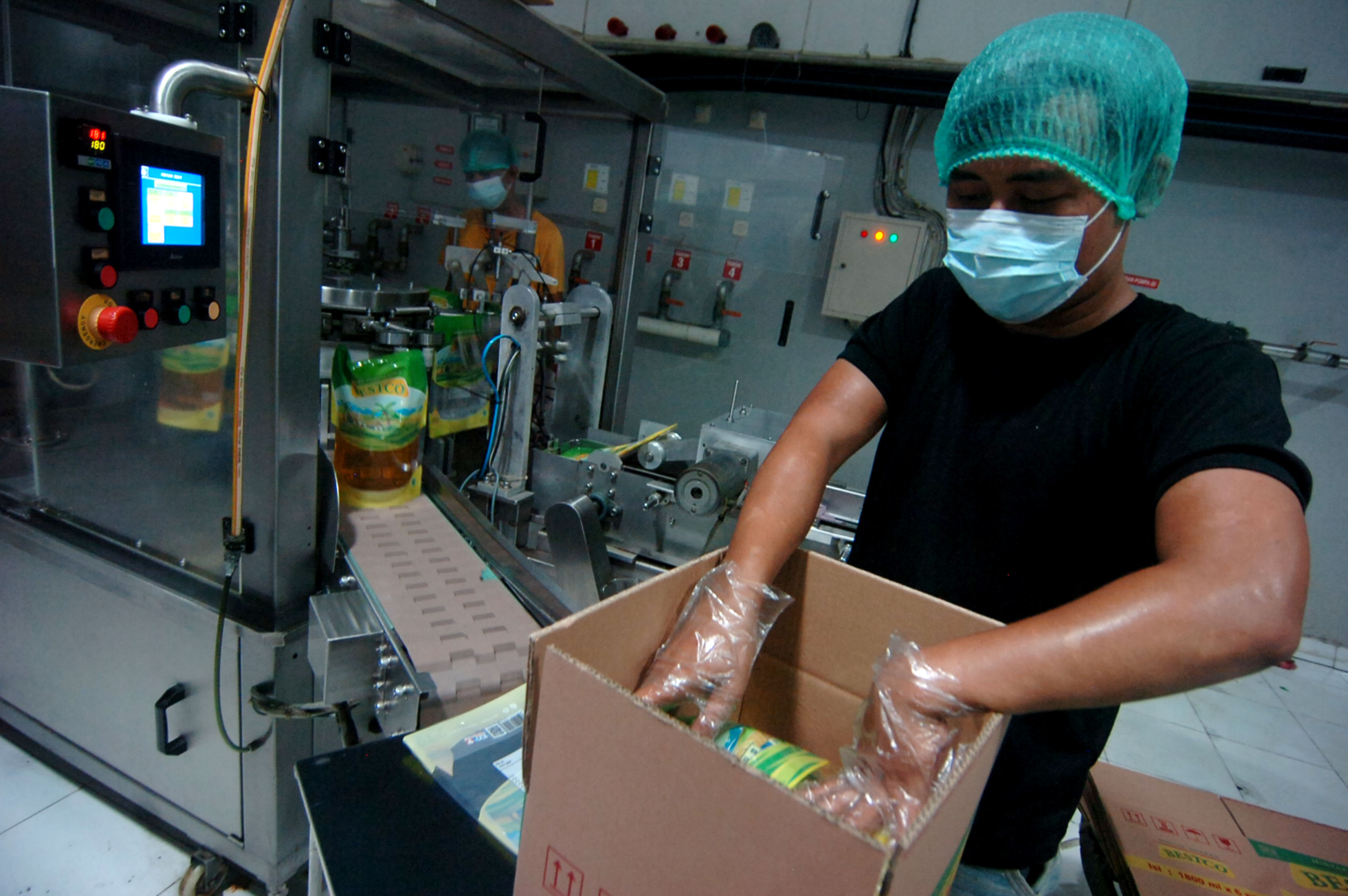  Pekerja melakukan pengemasan minyak goreng di kantor distributor di Tegal, Jawa Tengah. 