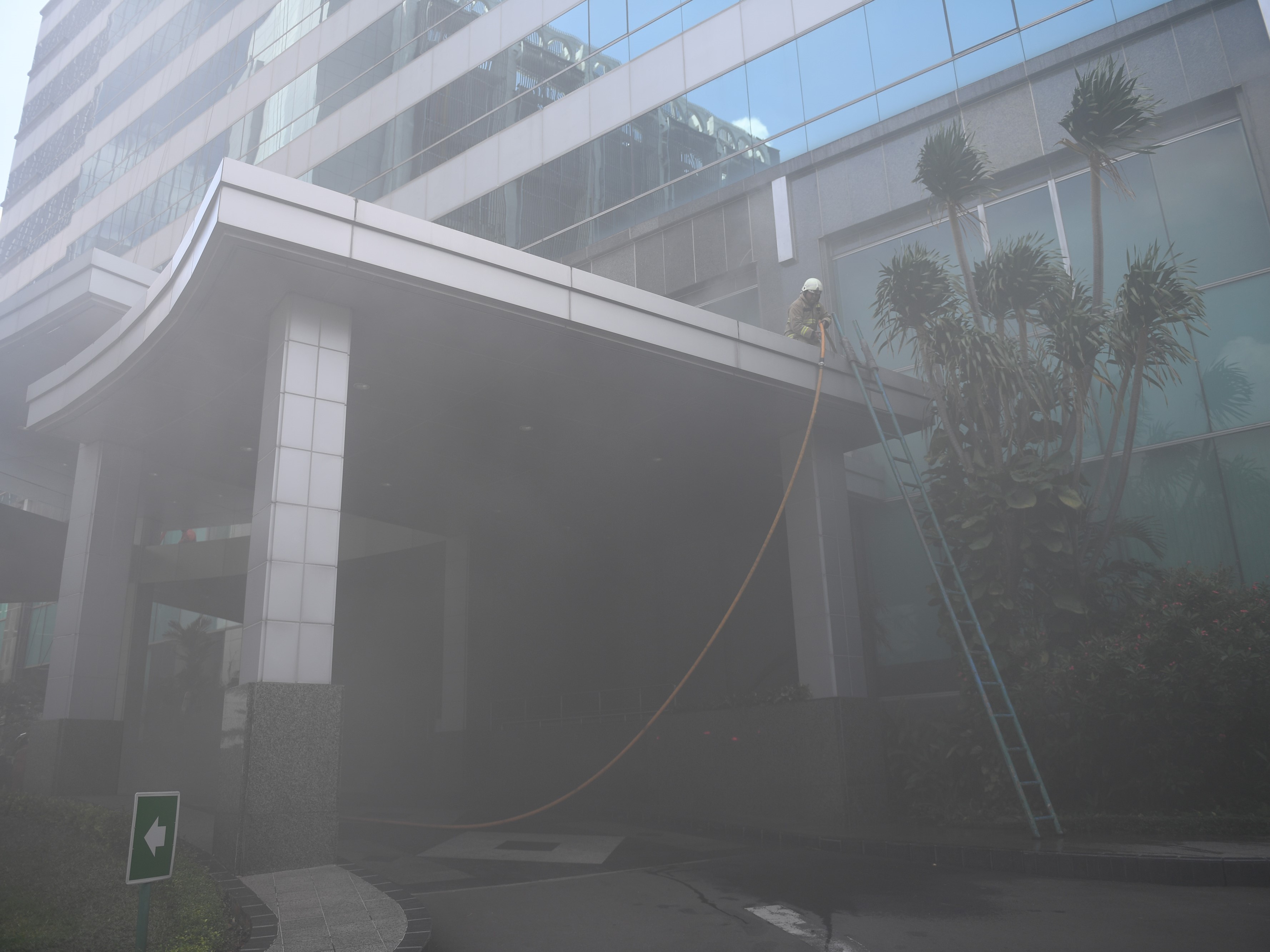 Petugas menerobos asap tebal saat berusaha memadamkan kebakaran yang terjadi di Gedung Cyber 1, Jakarta, Kamis (2/12/2021). 