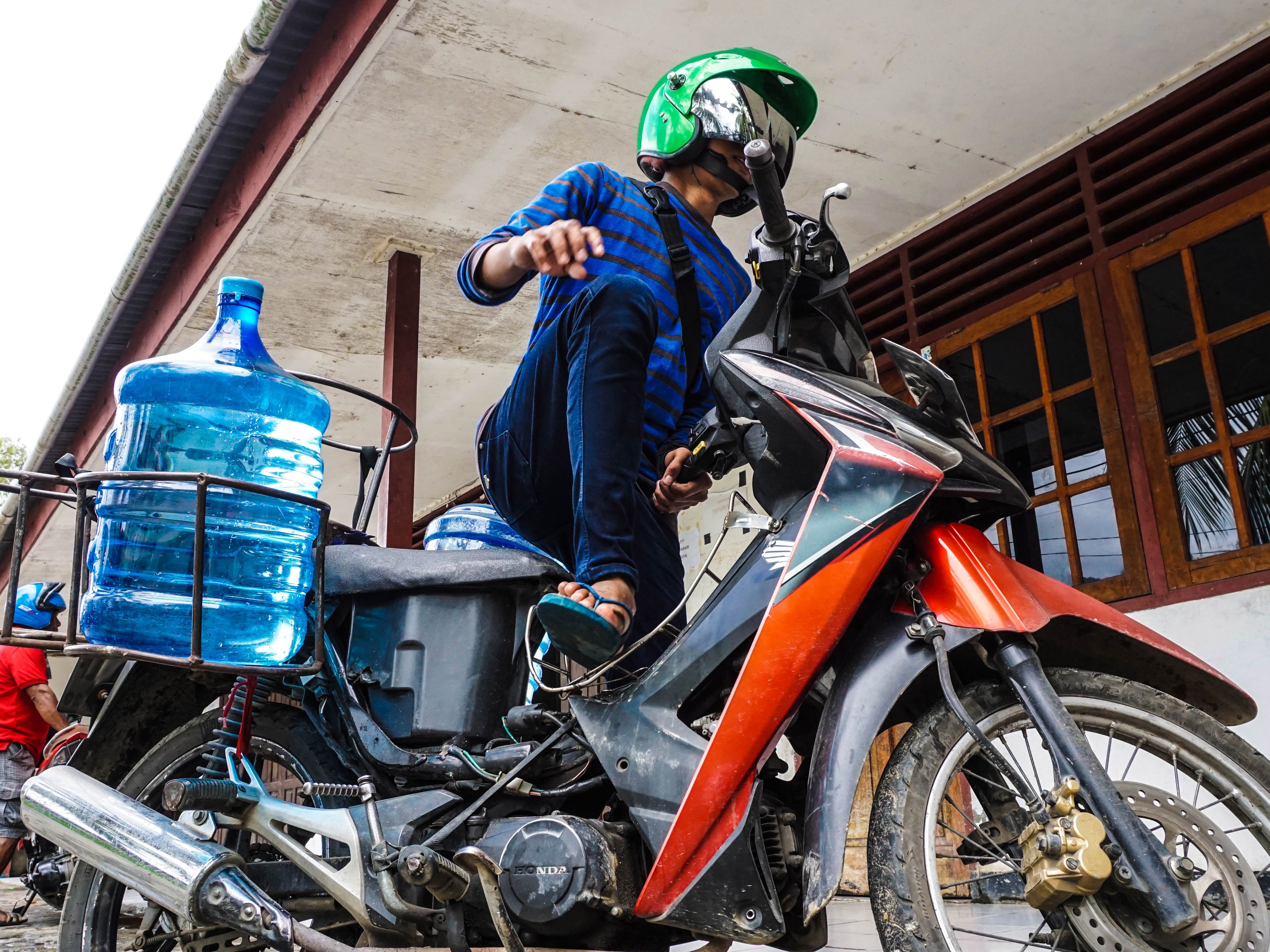 Seorang petugas depot siap mengantar pesanan air mineral kepada pembeli, di Serui, Kepulauan Yapen, Papua.