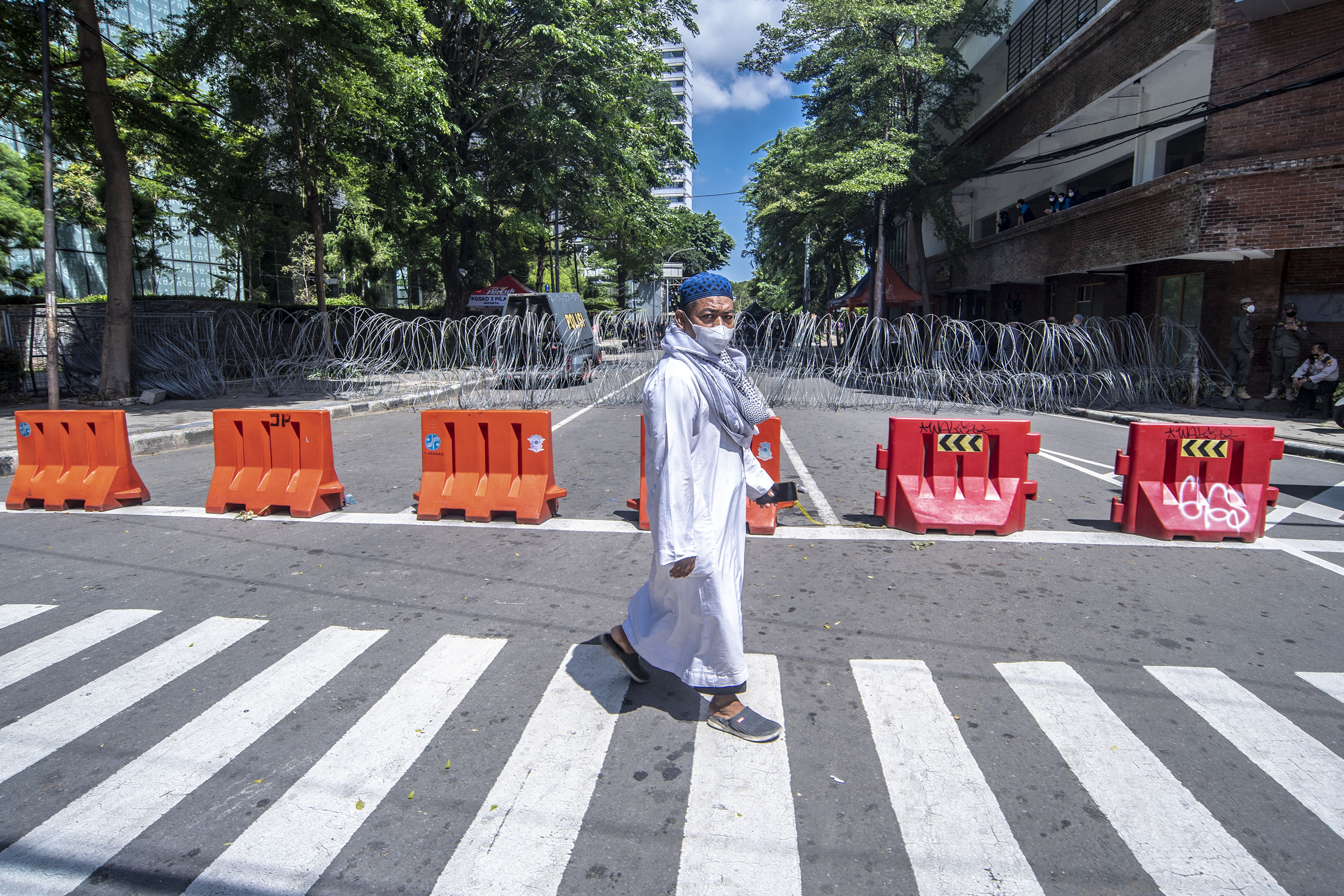 Peserta reuni 212 berjalan di depan barikade penyekatan