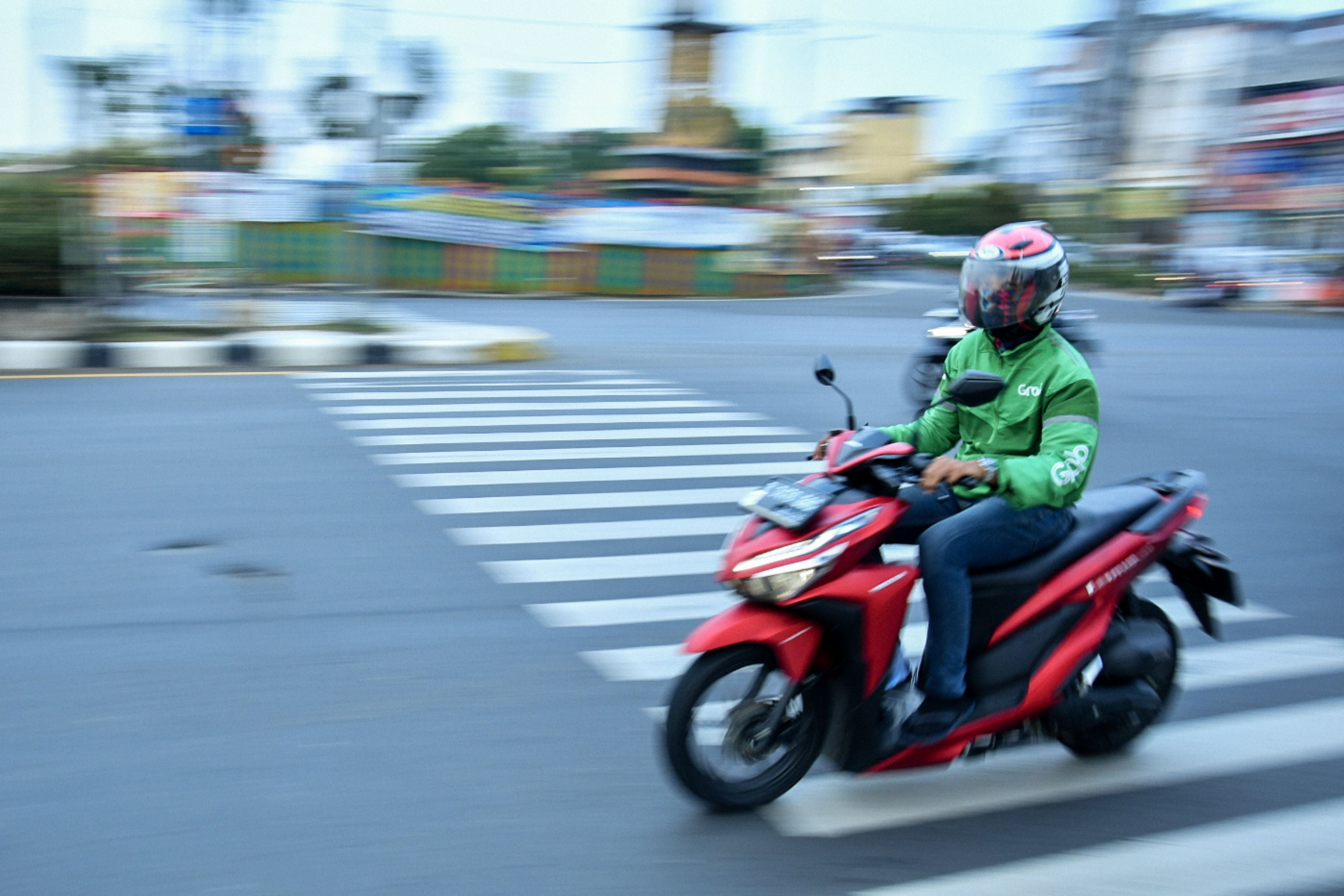 Pengemudi ojek daring Grab sedang melintas di Jalan Margonda Raya, Depok, Jawa Barat.