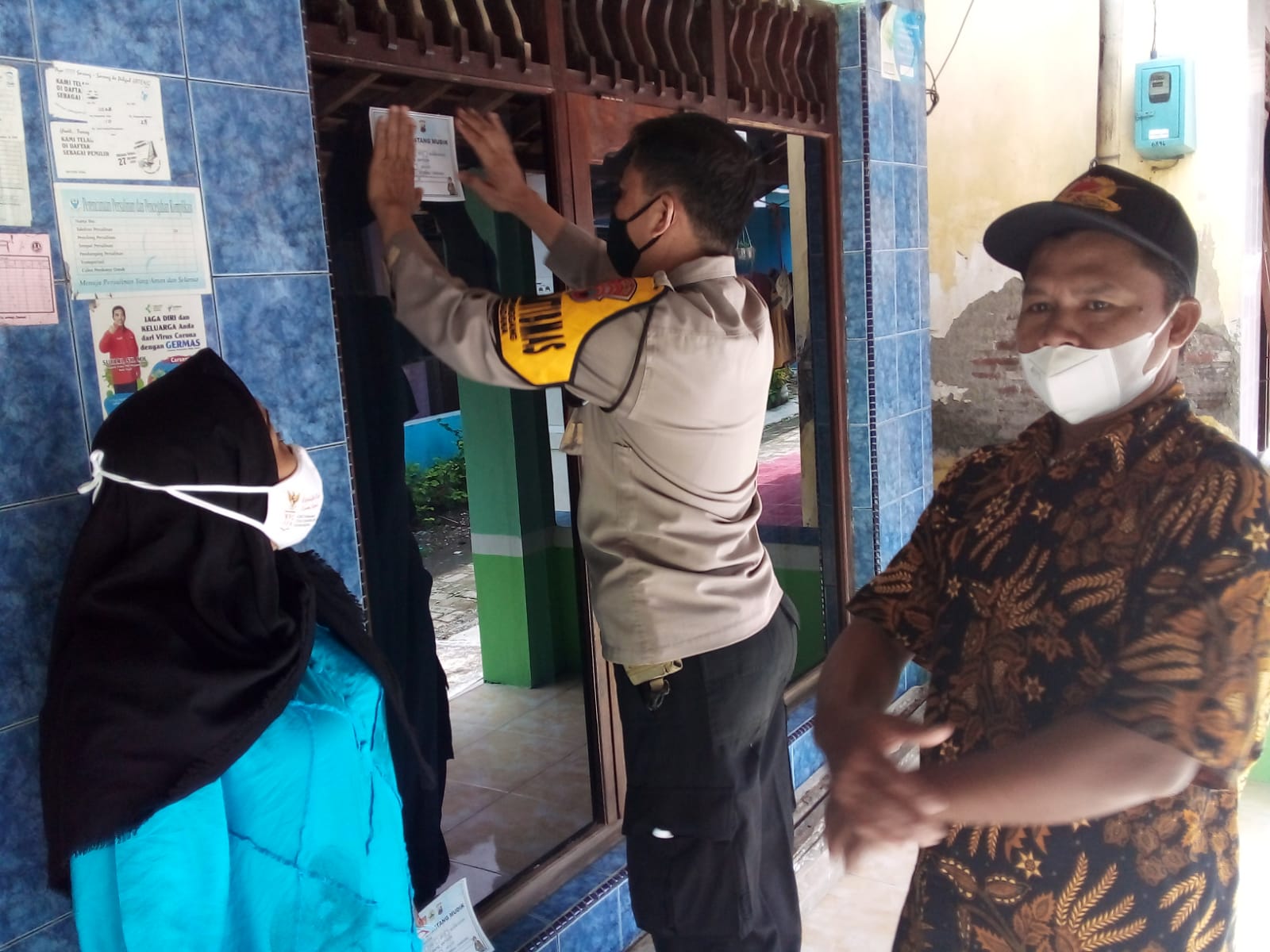 Petugas Polres Tegal Kota memasang siker di rumah warga pemudik Kota Tegal. 