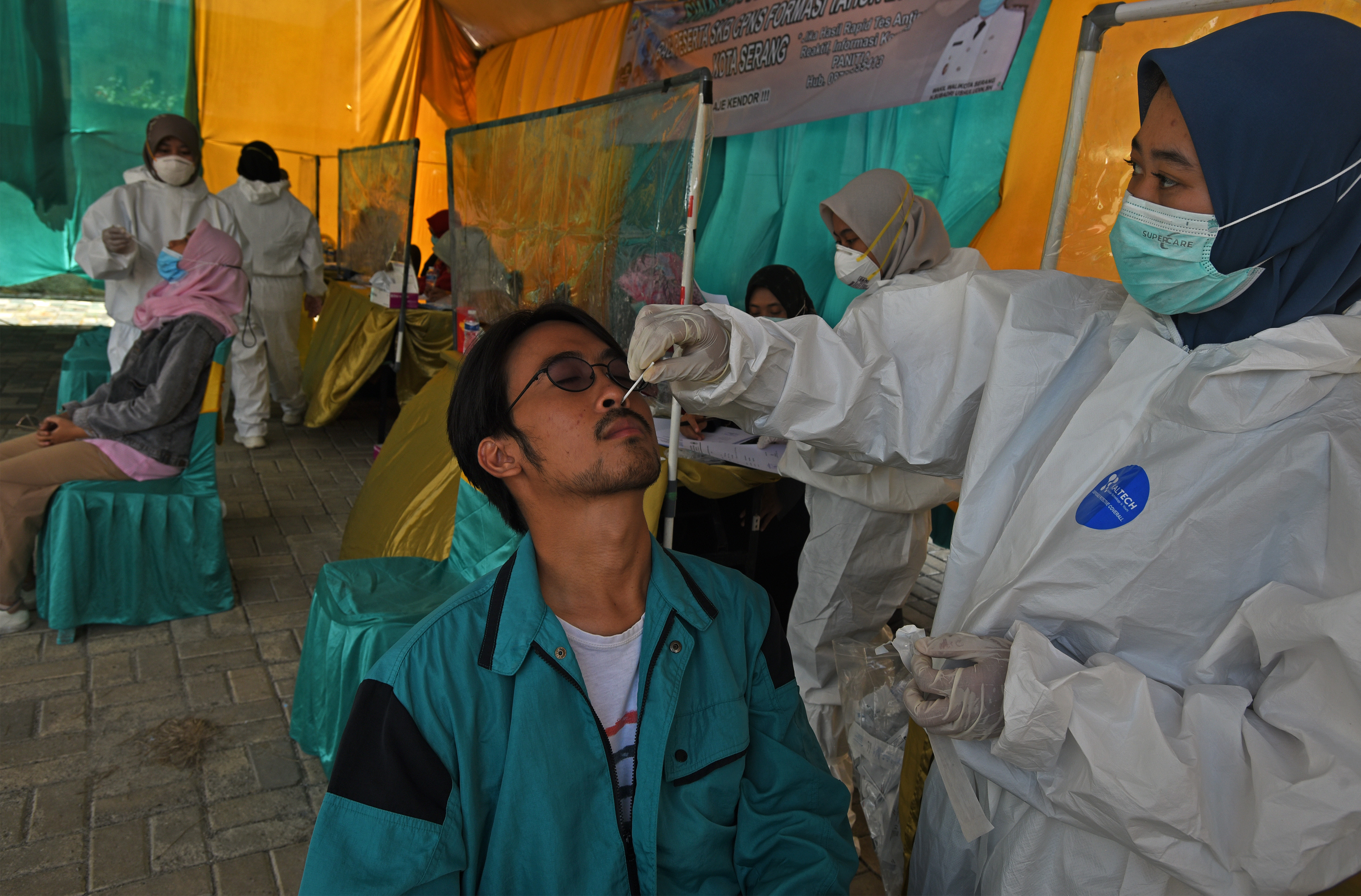  Petugas medis mengambil sampel lendir warga saat melakukan Tes Swab Antigen Peserta Seleksi CPNS di Serang, Banten, Sabtu (27/11/2021)