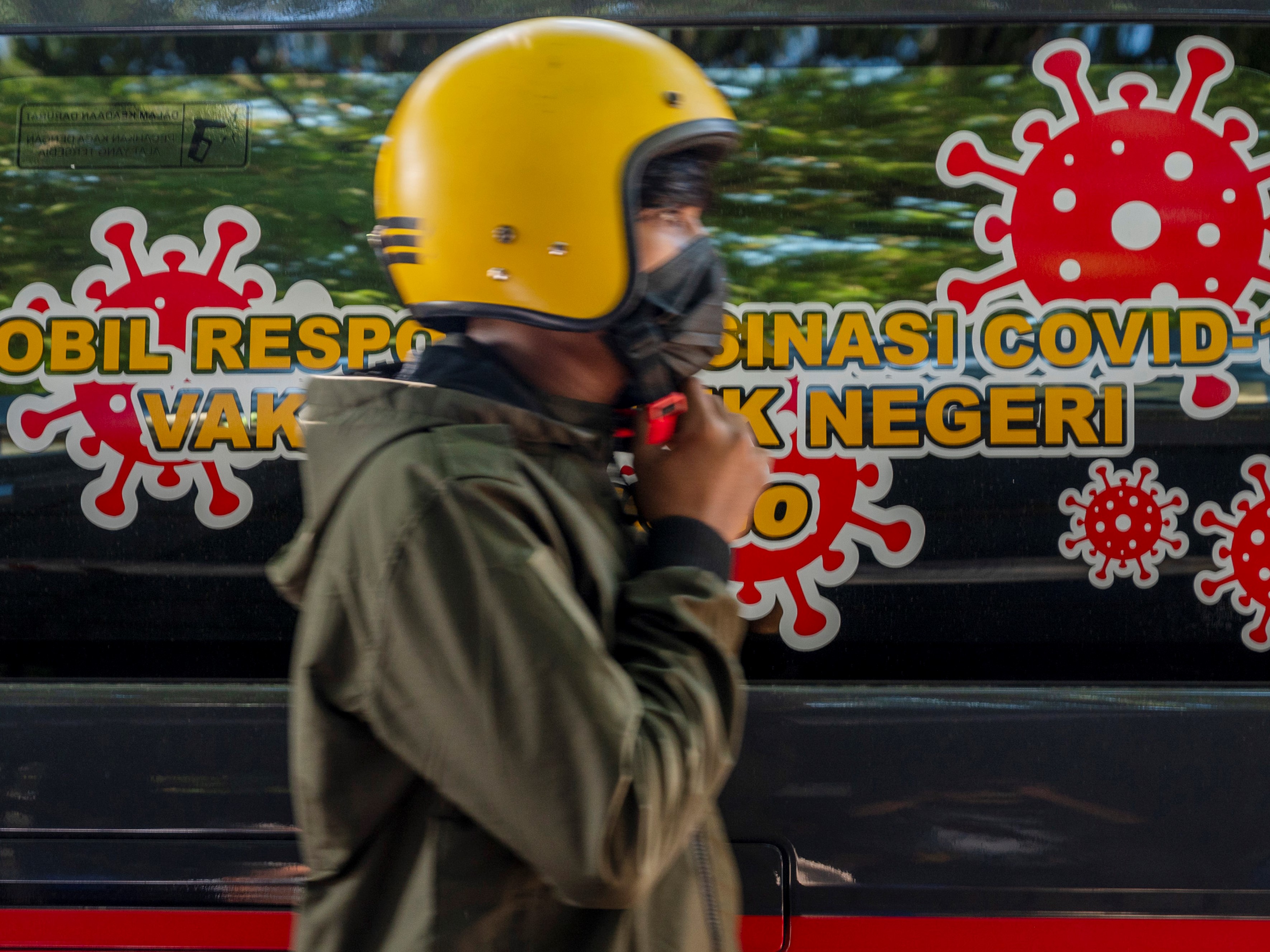 Warga melintasi mobil Respon Vaksinasi saat vaksinasi covid-19 oleh Polda Sulteng di Palu, Sulawesi Tengah, Rabu (1/9/2021). 