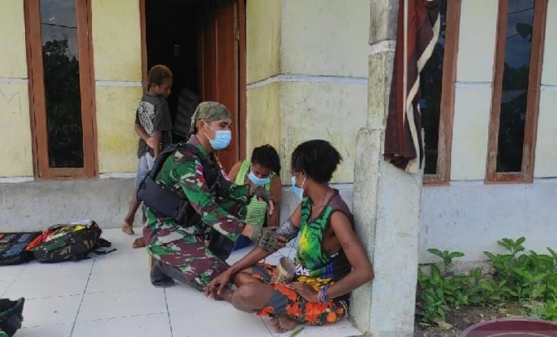  Personel Satgas Pamtas Yonif 711/Rks melayani pengobatan gratis dari rumah ke rumah warga di kampung Mosso wilayah perbatasan RI-PNG.