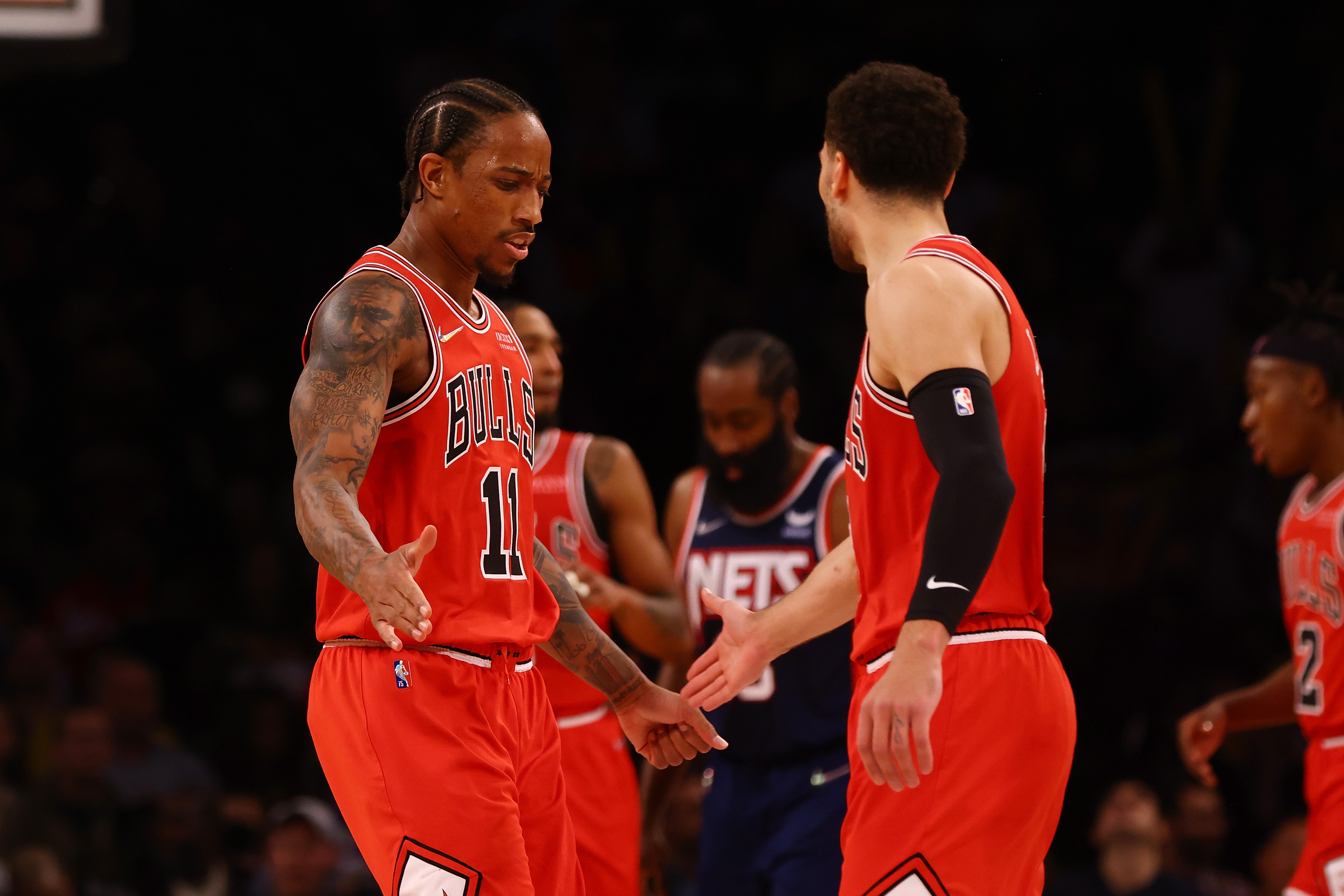 Dua pemain Chicago Bulls, DeMar DeRozan (kiri) dan Zach LaVine (tengah) melakukan selebrasi saat laga melawan tim Brooklyn Nets. 