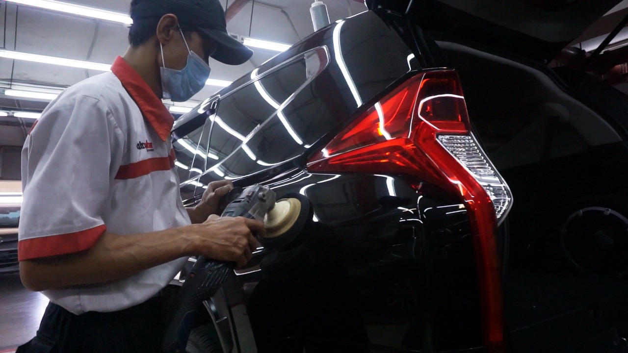 Ilustrasi. Seorang pekerja tengah membersihkan mobil.