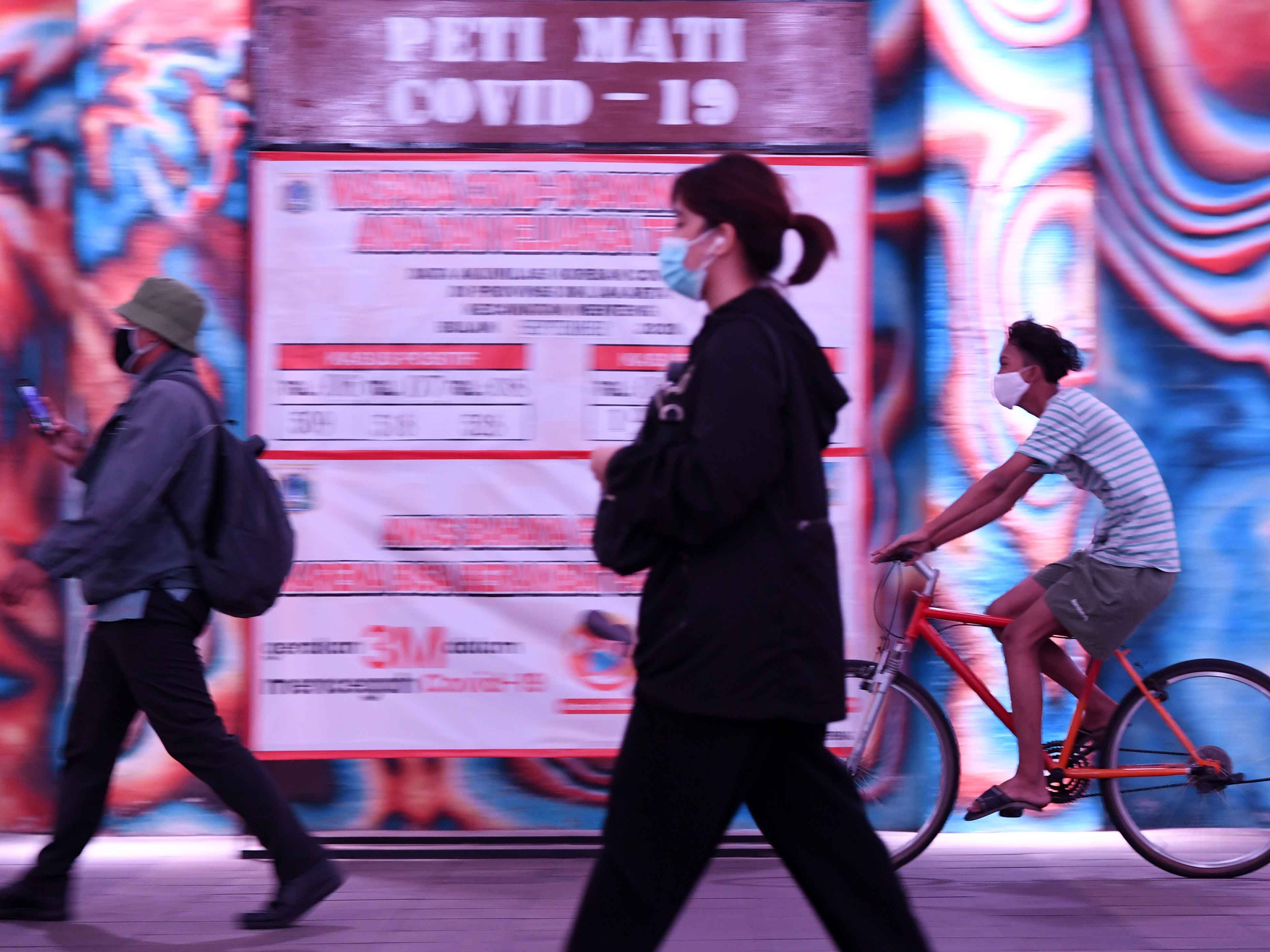 Warga melintasi replika peti mati, di Jalan Kendal, Jakarta